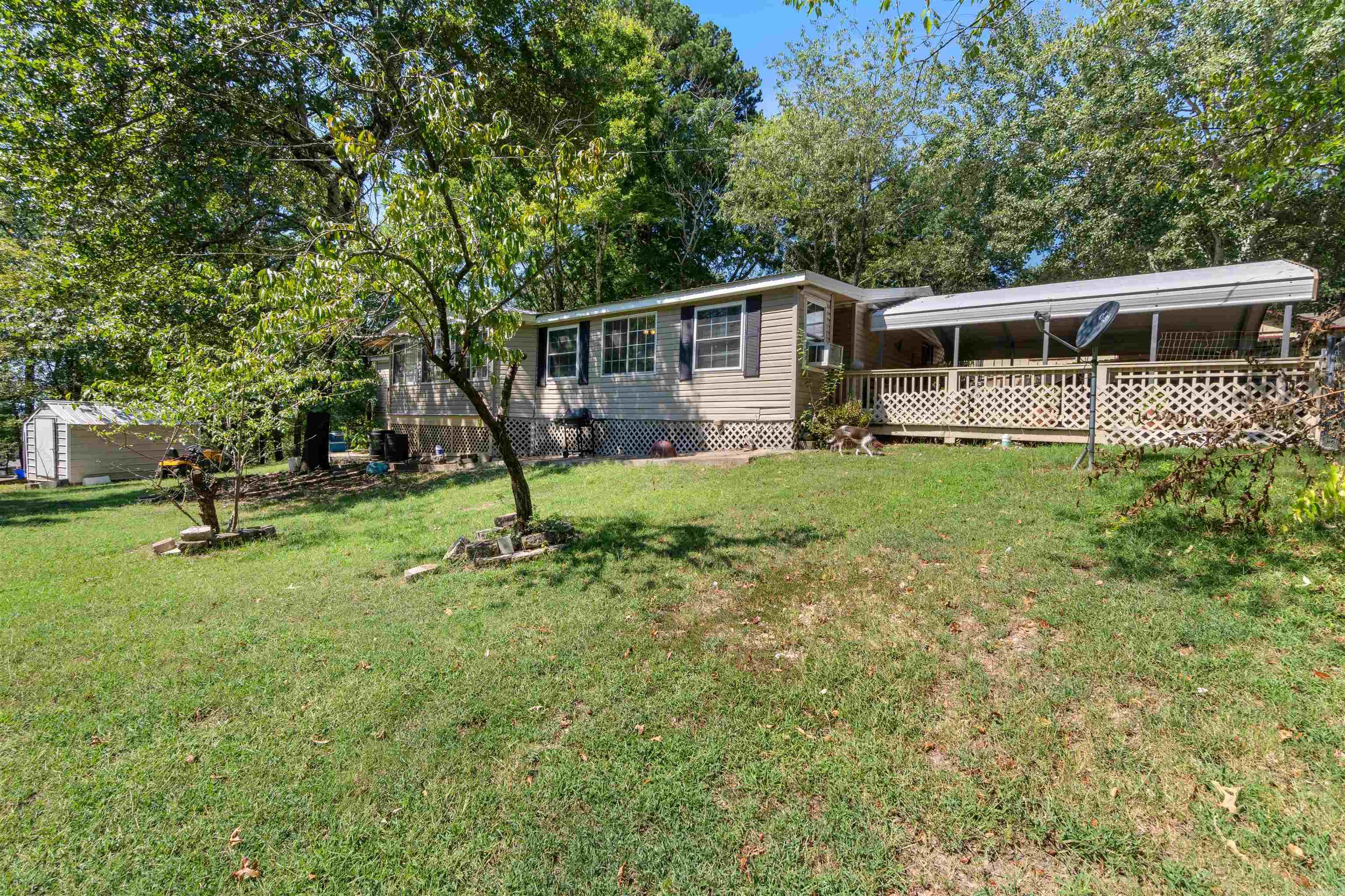Come see this extremely well maintained home with a newer metal roof (replaced in 2019), new water heater, and new accessible walk in shower. There's covered parking, a nice big yard and even though it's near town - it feels like secluded, wooded retreat.