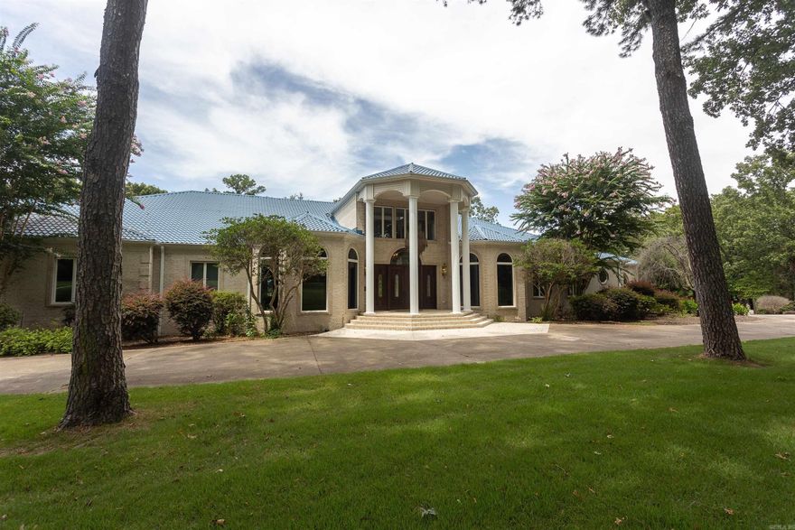 This may be your once-in-a-lifetime opportunity to own an iconic piece of Russellville history. Resting on the banks of Lake Dardanelle, this grand home is the epitome of luxury, exclusivity, and a life of peace. This majestic estate spans over 7 acres of park-like, manicured grounds, offering a tranquil retreat that is just moments from town. The grandeur of this stately home is immediately apparent upon entry, with its expansive 15,000 square feet of living space that includes a wonderful indoor pool and spa for year-round enjoyment. Boaters will delight in the private, 2-slip boat dock with lift, offering direct access to the beautiful waters of Lake Dardanelle. The property's own movie theater ensures unforgettable entertainment experiences to enjoy in the comfort of your own home. The carriage house includes over 3,000 sf of space, including an enclosed shop with bathroom which is climate controlled for your comfort. Please know that this property must be seen to be appreciated. Amenities like the elevator, main kitchen with 4 ovens and built-in sub-zero refrigerator, wine cellar and sauna are just a few of the luxuries you won't want to miss on your private tour of this home!