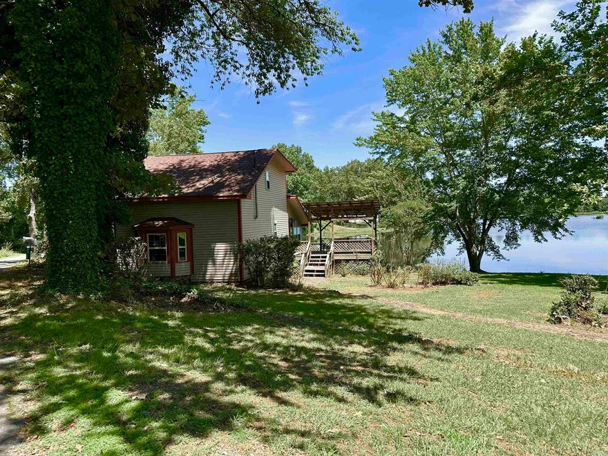 "Welcome to your lakeside retreat! This unique loft-style 1 BR 1 BA home offers a tranquil escape on over half an acre of pristine lakefront property. Imagine waking up to the serene view of the lake, with the option to fish right from the shore. Enjoy the peaceful lake with your morning coffee from the spacious open deck or under the covered deck area. Entire home has been newly painted including new carpet on stairs and LVP in the upstairs loft area! Roof approximately 4 years old, HWT around 6 years. Also, the vinyl siding insures a low maintenance exterior. Separate single car Garage is large enough to store all your yard and fishing equipment too! Downstairs has a large living area with windows overlooking the lake. Dining area has cozy fireplace! Large kitchen with tons of cabinets and counter space. Refrigerator, washer and dryer stays! Bedroom and bathroom are upstairs with large walk in closet and lake views!  Ideal home for anyone seeking a peaceful getaway or a charming permanent residence. Short term rentals could be an option too! Close to the back gate of LRAFB & Hwy access & shopping.  Don't miss out on this opportunity to own your own slice of lakeside paradise!"--