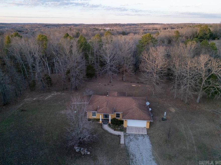 62± acres on Elizabeth Road in Viola, AR with a 1,440 sq ft 3BR/2BA home plus 1-car garage built primarily of split-face concrete block. Winding gravel drive through mixed hardwood, pine, and cedar timber opens to a private yard with 30x20 shop, 24x12 storage building, chain-link dog pen, and a year-round spring. Valley behind home offers potential food plot area with deer and turkey sign. Open-concept kitchen/living with tile floors, solid wood cabinets, solid-surface countertops, and wood-burning fireplace. Primary bedroom has wood floors and walk-in closet; primary bath features tile-floor with shower. Guest bedrooms have wood floors and closets; guest bath has tub/shower combo with tile flooring. Utilities include private well, NAEC electric, NEXT Fiber internet, septic. Electric HVAC and electric water heater. Appliances convey: refrigerator, oven/range, washer, dryer.