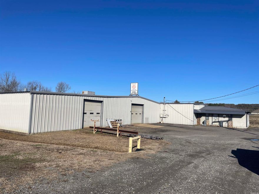 Has 2 bays. Bay 1 includes 9,375 sq. ft. of Shop Space, which includes a 10'x12' ft bay door, shop walk through door and office door. Also includes one shop bathroom, 800 sq. ft. of Office Space with one restroom. Includes 890 sq. ft. of covered storage in back of building. Bay 2 includes 2,500 sq. ft. of shop floor space, 2 Bay Doors. 200 amp service and has power for single and 3-phase machine hookup.