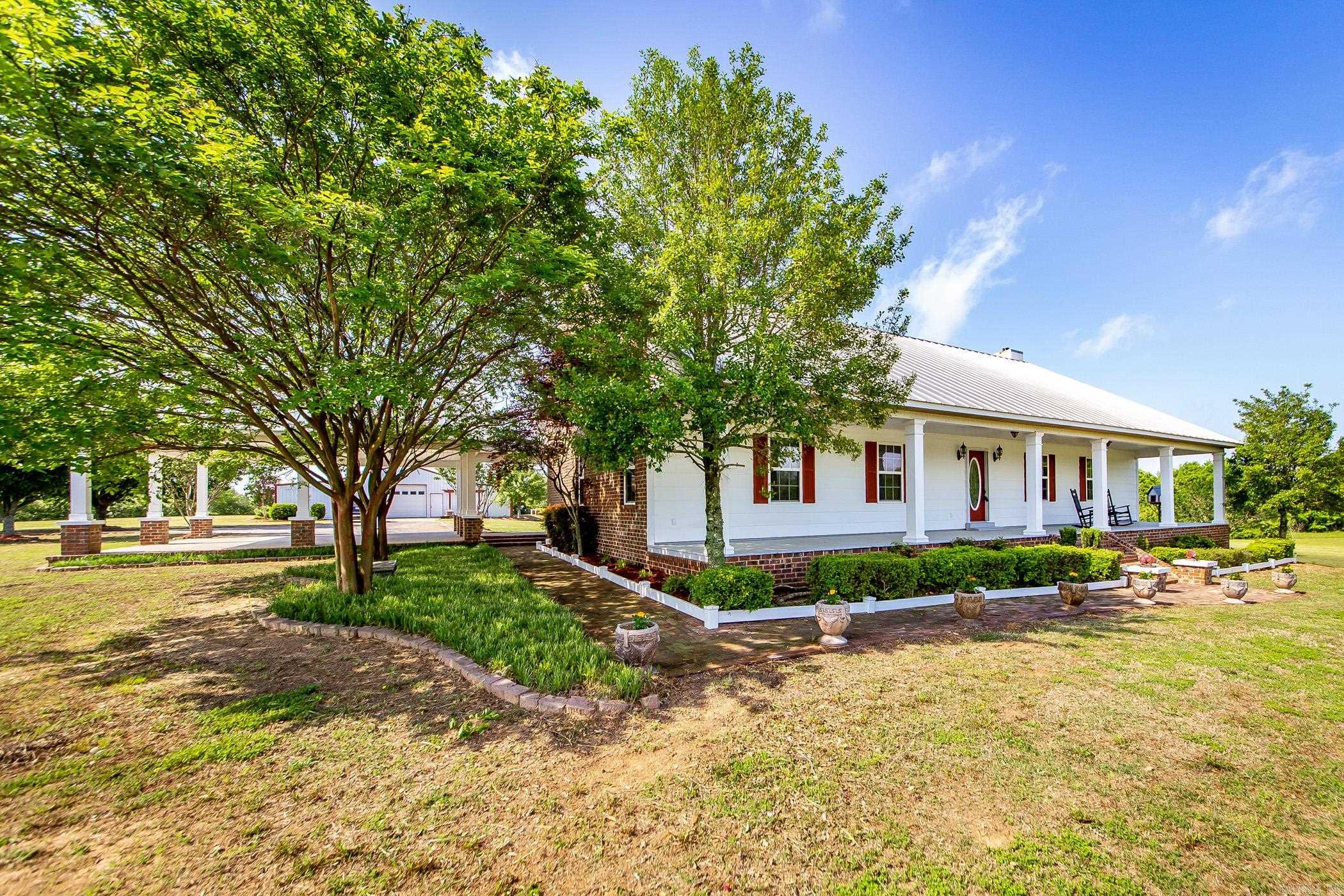 What a panoramic view! Beautiful, countryside beauty from every side of the home! From the rocking chairs on the front porch to the covered 25 x 25 back porch-mother nature surrounds you! Extremely well built home with geo thermal unit for heat/air source, metal roofing, solid hand scraped wood flooring, slate tile flooring in wet areas, high end appliances, cherry cabinetry and beautiful decor throughout! Even solid wood interior doors! Wood stove in living space for cozy comfort. Upstairs features a huge bedroom and full bath-zoned units for heat/air. 30x40 shop including a 12x40 full apartment with washer/dryer. 20x32 RV cover, 11x40 boat shed, 12x12 storage shed and sweet gazebo overlooking pasture. Only 20 minute drive to Cabot or Searcy with NO traffic! See documents online for survey, disclosure, etc.