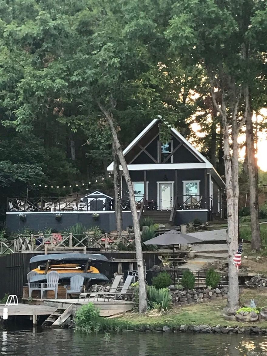 Don't miss this rare opportunity to own a beautifully placed lakeside cottage on the peaceful shores of Lake Norrell in Saline County. This 840 sq foot, 2 BR, 1 Bath, home offers cozy comfort, efficient design & stunning lake views.  The open-concept floor plan combines the living & kitchen aea into a bright welcoming space, perfect for relaxing or entertaining. 2nd bedroom is a loft-style accessible by ladder, adding character & extra sleeping or storage space.  Full bath features a walk-in shower.  Set on a spacious, well-positioned lot, the home maximizes lake views and outdoor enjoyment.  Multiple seating areas, firepit and mature trees creates the ideal backdrop.  A covered dock makes lake access easy and convenient for boating, fishing or swimming.  Includes a detached 6 x 8 outdoor storage area.  Front covered porch is 20 x 8, deck is 15 x 24.
