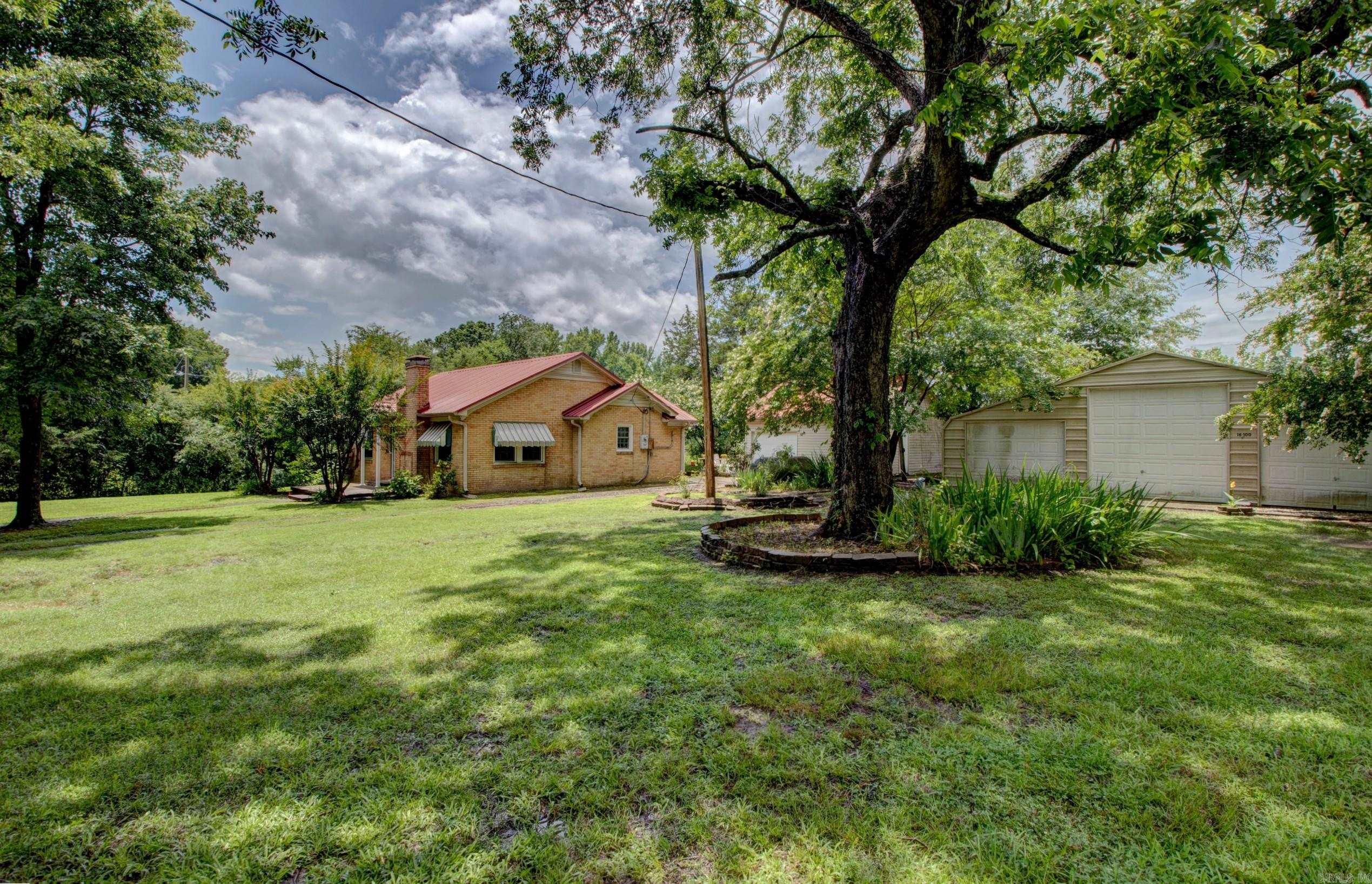 The Morgan House, built late 1950 blends vintage charm with thoughtful updates. This 2/1 home features original birch kitchen cabinets, rare aquamarine appliances, oak hardwood floors, picture rail & antique lighting. The living rm includes a buff brick fireplace w/cast enamel gas stove. Vintage-tiled bathroom is oversized for its era & natural light fills every room. Set on a beautifully landscaped lot, the property includes 2 patios, mature trees, blooming shrubs, and a unique Elvis Oak grown from a Graceland acorn. Updates include a new red metal roof, custom windows, full crawlspace encapsulation with sump pump & dehumidifier, and new septic system. A 36x30 three-bay garage/shop complements the original detached garage/workshop/office with added concrete flooring. This lovingly cared-for home offers rare character, history, and comfort in one package. Agents: See Remarks & Documents for addt'l amenities & detailed plant varieties and more