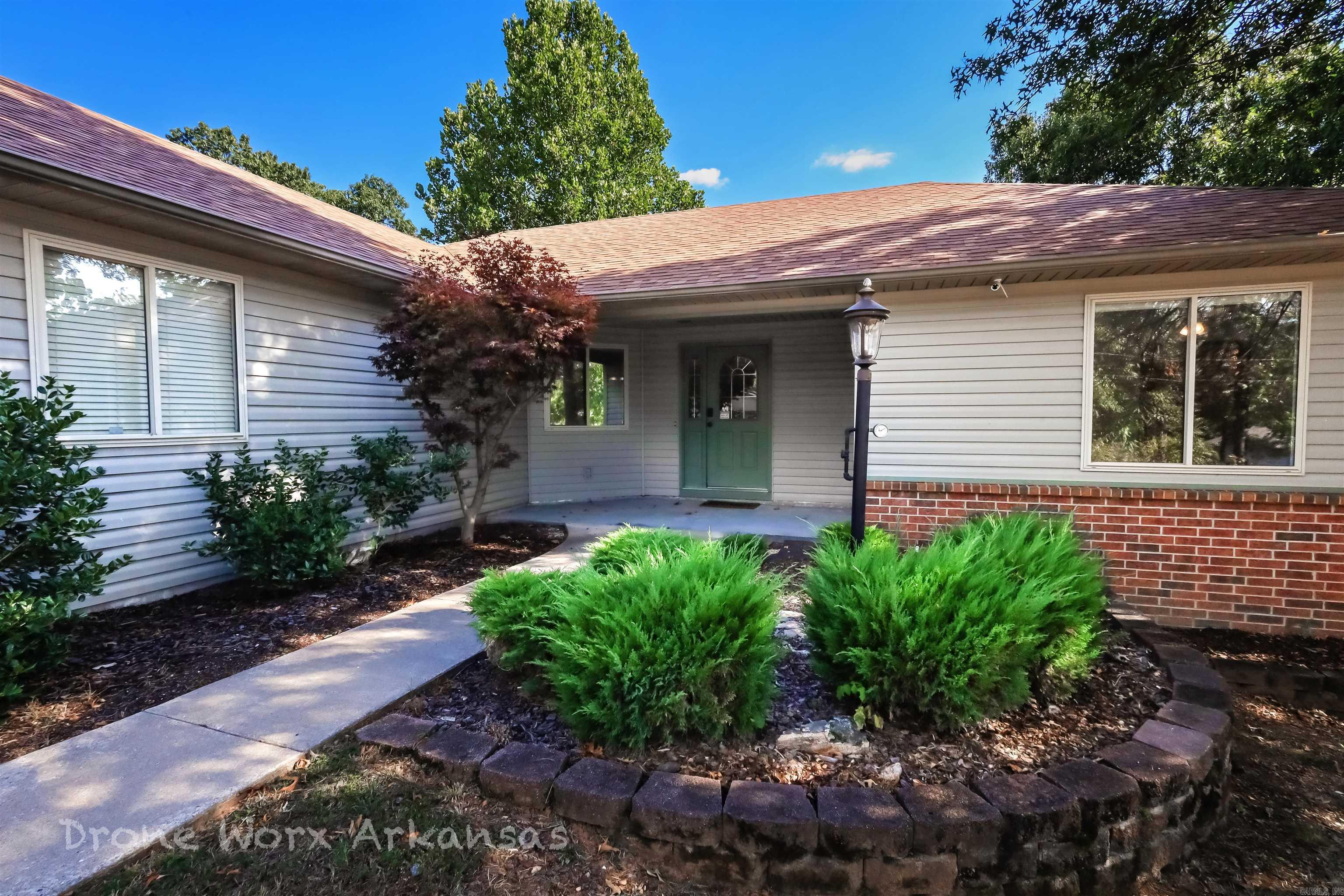 Inviting 3BR, 2BA home with 1,734 sq ft, tucked away on a quiet cul-de-sac in Bella Vista. The split floor plan offers privacy and comfort, with spacious living and dining areas ideal for everyday living or entertaining. The kitchen flows into the main living space, and the private primary suite features a walk-in closet and a large bathroom with a walk-in shower and jetted tub—perfect for relaxing. Bedrooms currently have carpet, and a flooring allowance is included to replace it. Step outside to a large back deck and expansive patio overlooking a wooded area, with a designated space ready for a hot tub. Recent updates include HVAC, roof, and kitchen appliances. The two-car garage offers ample storage for bikes and outdoor gear. Just down the road from the popular Blowing Springs mountain bike trail, this home blends modern comfort with NWA's outdoor lifestyle. A must-see in a great location!