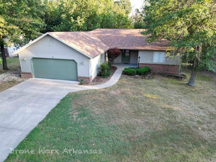 Trailside energy. Peaceful living. This home delivers the perfect mix of outdoor fun and quiet comfort, less than a mile from the Blowing Springs trailhead and just minutes from town. Tucked away on a peaceful cul-de-sac in Bella Vista’s Primrose subdivision, this 3-bedroom, 2-bath home offers a relaxed, easygoing lifestyle surrounded by nature. The open living area is warm and inviting, flowing effortlessly into a private backyard retreat. Step outside to a spacious deck and patio overlooking the trees—perfect for morning coffee, cozy evenings, or entertaining friends after a day on the trails. There’s even room ready for a hot tub or firepit to make the space your own. A split floor plan adds privacy, with the primary suite featuring a walk-in closet and a spa-like bath complete with a walk-in shower and jetted tub—ideal for unwinding and recharging. A carpet allowance for the bedrooms gives you the opportunity to add your own personal touch. Recent updates to the roof, HVAC, and kitchen appliances bring peace of mind, while the two-car garage provides plenty of room for outdoor gear and storage. 9 Piccadilly Lane is your adventure hub, in the heart of Bella Vista.