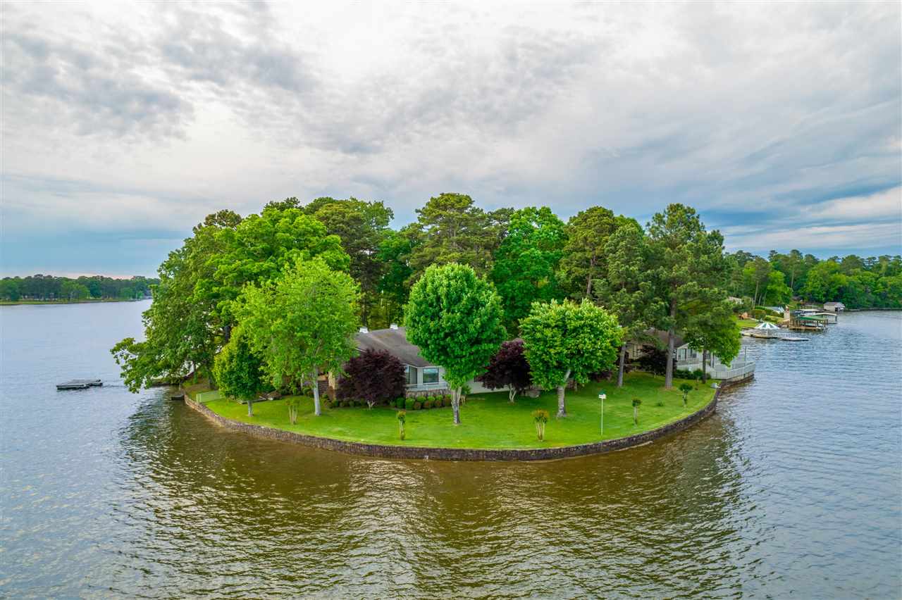 Must see this iconic property located at the Point of Ledgerwood Rd. This property boasts almost 500' of Lake Hamilton Frontage and has breathtaking views throughout. The main house features 3 Bedrooms & 3 Bathrooms, open concept kitchen/living/dining, beautiful wood beams, incredible architectural details, and multiple patios to enjoy the most unique property on Lake Hamilton. The guest house features 2 Bedrooms and 2 Bathrooms, with a screened in porch and a large deck overlooking the main channel.