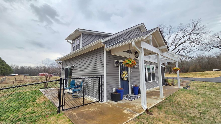 Luxury Meets Efficiency in These Two Beautifully Designed Smart Tiny Homes! 1st Built in 2021, features a 2-bedroom, 1-bath open floor plan with tall vaulted ceilings, quartz countertops, smart stainless kitchen appliances, tile shower, stove, washer and dryer, built-in wine rack, island, fireplace, tankless water heater, LED lighting, black chain-link fence, Trex decking for the patio to enjoy the hot tub and entertaining area, plus a screened-in porch and paved driveway. Both homes sit unrestricted on a perfectly positioned 1.63 acres directly across from the Riverland Golf Course, with no HOA fees. 2nd addition in 2023 is a guest or mother in law quarters includes, quartz countertops, fireplace, stainless kitchen appliances, concrete sidewalks, raised garden beds, private drive, tiled shower, LED lighting throughout, and an expanded entertaining area with soft lighting and a porch swing—perfect for entertaining or relaxing. Both properties are offered as turn-key, ready for immediate enjoyment—ideal as a full-time residence, weekend retreat, or short-term investment opportunity.