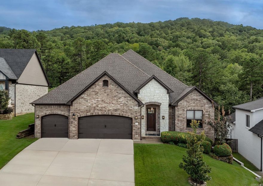 Come see this beautiful one-level, one-owner Chenal home that was built in 2019 and has been meticulously maintained with a THREE car garage. There are hardwood floors through all living areas, with granite countertops and stainless appliances in the spacious open chef's kitchen featuring a gas cooktop, wall oven, generous serving space, walk-in pantry and a coffee bar. The expansive island layout overlooks the dining, and living areas.  The great room features a beautiful gas fireplace overlooking the beautifully landscaped backyard. Enjoy meals overlooking the backyard oasis with lush landscaping and private greenspace.  Step outside to a covered patio with an outdoor gas fireplace and expansive patios a new Trex composite decking patio—ideal for relaxing or entertaining. The primary suite is a dream— with double vanities, a walk-in shower, soaking tub, and a spacious closet that connects to the laundry room. There are Granite Countertops throughout the home.  This beautiful home with great curb appeal and a great floor plan is move-in ready.