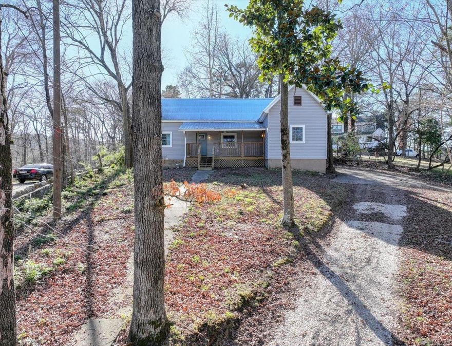 Nestled on a hill in downtown Hot Springs, this wonderful updated home offers exceptional views of the Hot Springs Mountain Tower and a private front yard over looking a wooded vacant lot. Fully rehabbed seven years ago with new electrical, plumbing, windows, metal roof, and vinyl siding. Recent upgrades include brand-new flooring and fresh paint throughout, plus new covered decks on both front and back porches. Move in ready and ideally located.