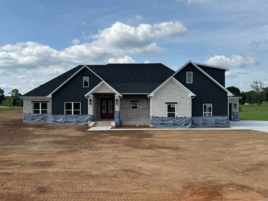 Stunning new construction home blending modern design with timeless craftsmanship. This open-concept layout features spacious living areas filled with natural light, soaring ceilings, and beautiful exposed wood beams that add warmth and character.  The gourmet kitchen is the heart of the home, showcasing custom cabinetry, a large center island, and ample space for cooking and entertaining. The living and dining areas flow seamlessly, with expansive windows and sliding glass doors that bring in scenic views and create an inviting indoor-outdoor feel.  Enjoy wide-plank flooring, designer finishes, and thoughtful details throughout. The home also offers well-appointed bedrooms and stylish bathrooms, including a spacious primary suite.  With striking curb appeal, plus a covered outdoor area perfect for relaxing or hosting, this home delivers comfort, style, and the benefits of brand-new construction.