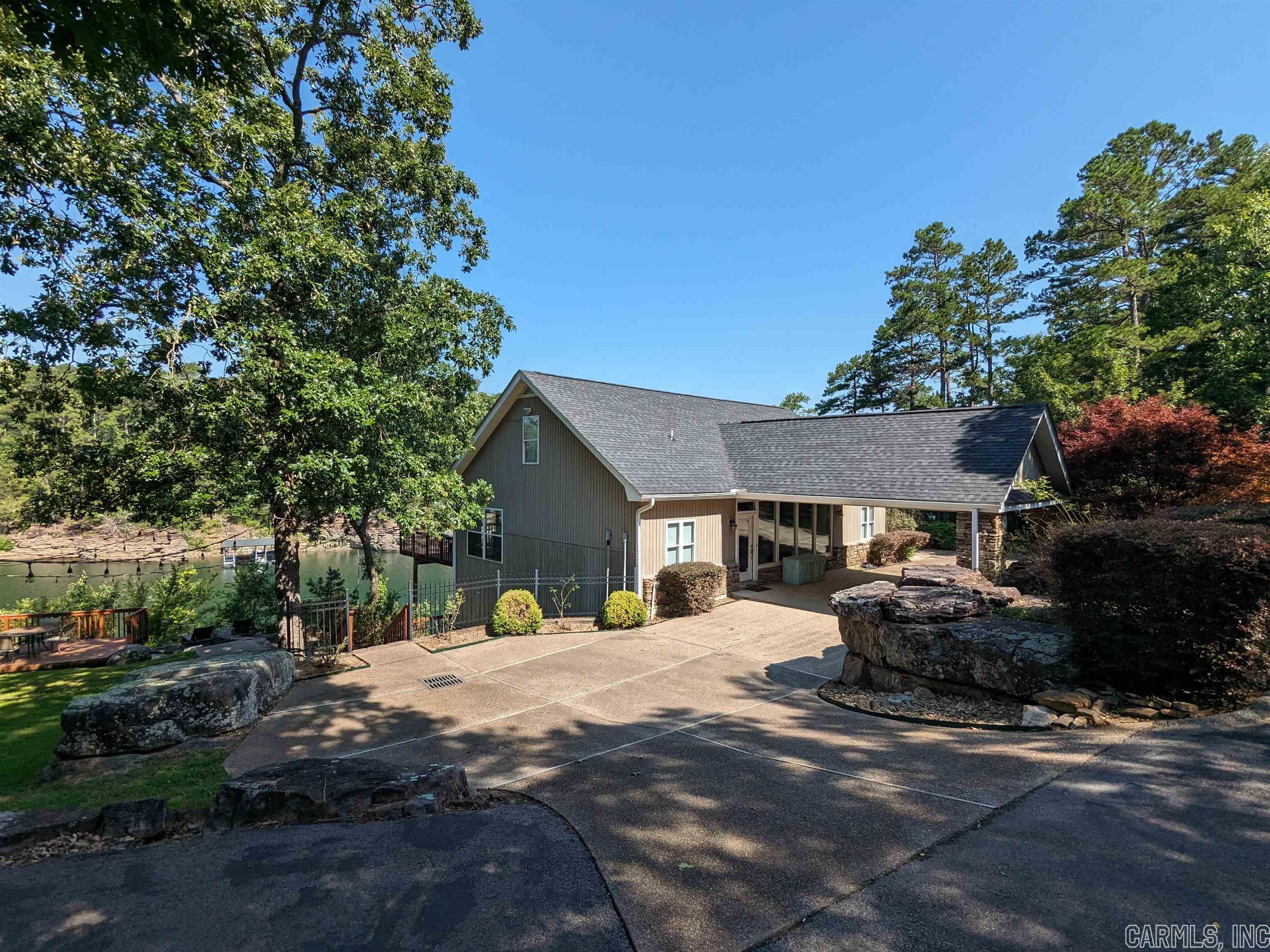 Dream Lakefront with a Boat Slip! This 4 bedroom 3.5 bath home features kitchens on both floors, large beautiful windows, open living, vaulted ceiling in main living, screened porch, new roof, new HVAC, and lots of privacy. The acre and a half includes a large 40x40 metal shop building. The boat dock is a very short walk down a private path and includes a 30' slip with a solar powered Ozark Lift. Home will come fully furnished with good offer! Stunning property!