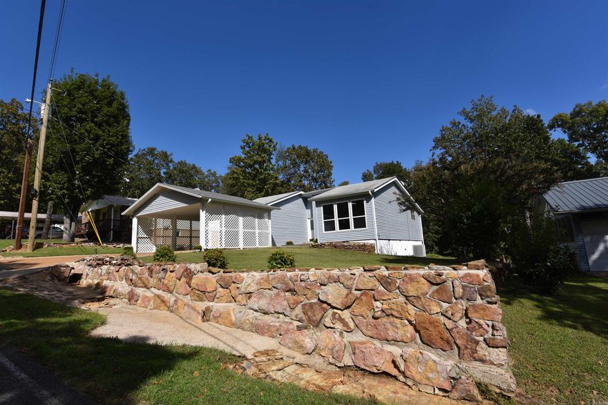 Discover this move-in-ready, charming home in picturesque Fairfield Bay, Arkansas. The welcoming stonework & delightful courtyard lead into a spacious, well-lit living space. The residence boasts luxury vinyl plank flooring & a freshly painted, neutral color palette. The kitchen is equipped with a handy breakfast bar that opens to the dining area. Relish your morning coffee or an evening drink on the covered deck with views of the serene, tree-filled backyard. The primary bedroom offers deck access, and the en suite bath features a separate sink and dressing area apart from the walk-in shower. Both baths have blue-tooth compatible speakers. The spacious carport, storage shed, and additional crawl space storage will be valued by the new homeowner. This 1 level, well maintained home is sure to impress. With proximity to the exceptional amenities the community provides, including 2 golf courses, 3 swimming pools, a full-service marina, pickleball & tennis courts, ATV/UTV trails, and just moments away from the unspoiled Greers Ferry Lake, this is an opportunity in the Ozarks not to be overlooked. Washer/dryer to convey with property. Third bedroom was a conversion has new heat&air unit