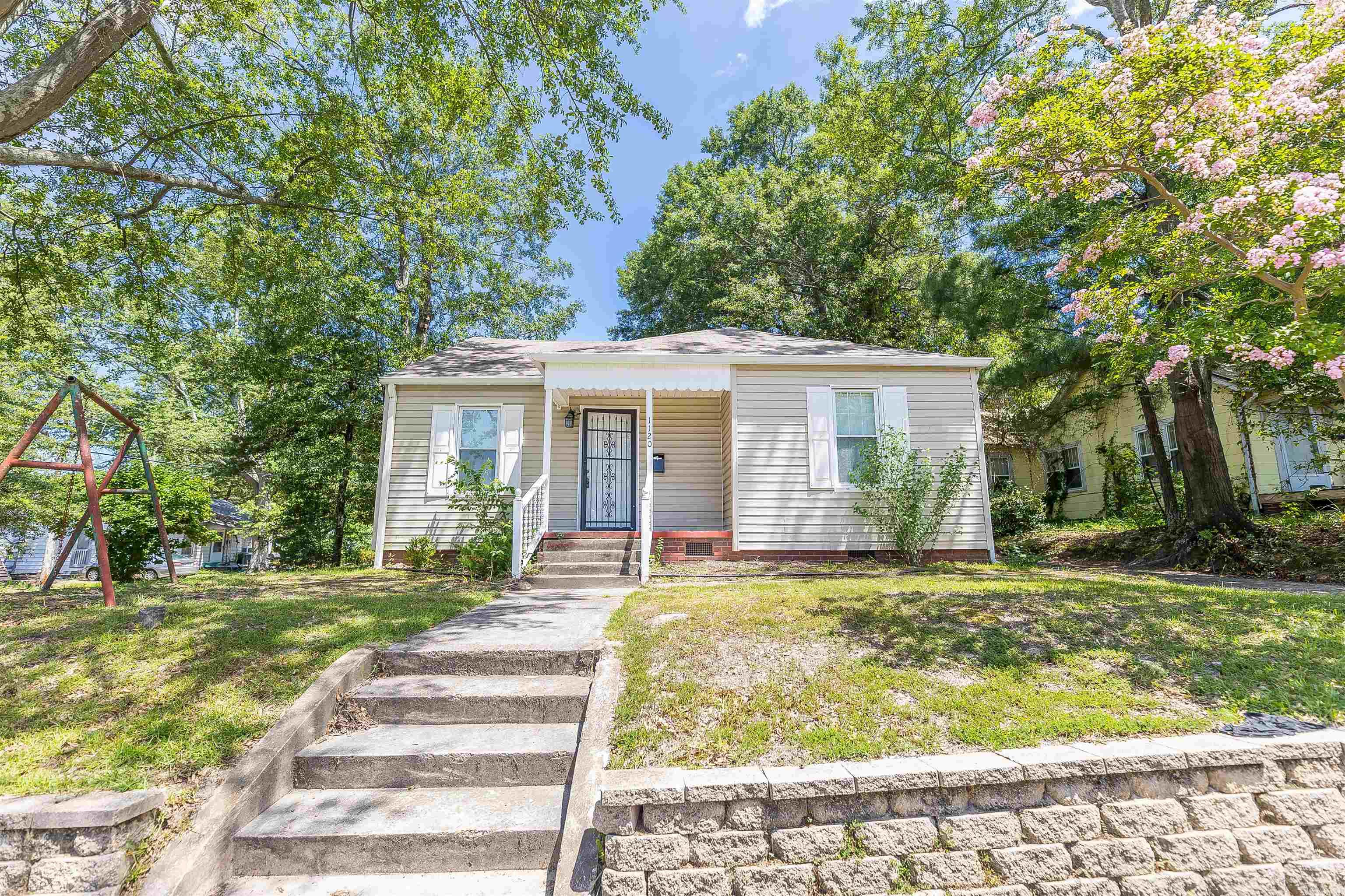 Charming home on an elevated corner lot, featuring a spacious kitchen, heightened ceilings, updated bathrooms, privacy fence, covered back deck, extra storage in the outbuilding, newer central HVAC, windows and roof, and easy-care exterior. The layout could easily accommodate the restoration of a 3rd bedroom if preferred.