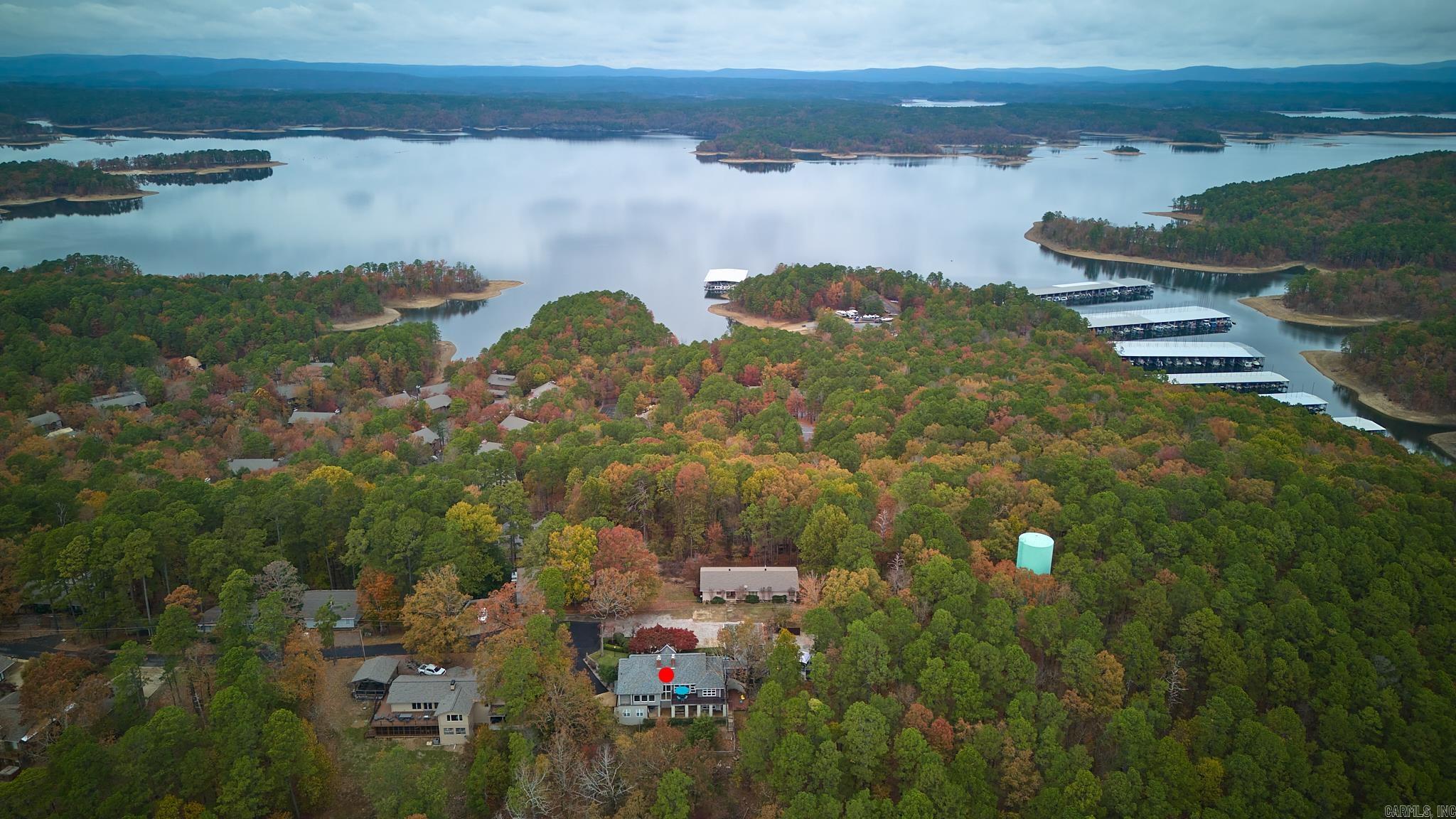 Nestled in the heart of sought-after Mountain Harbor Resort, this charming Lake Ouachita retreat offers a slice of paradise for those seeking tranquility & natural beauty. This spacious 3-BR., 2.5-BA home boasts an impressive 3,320 sq. ft. of living space, perfect for families or those who love to entertain. Step onto the large deck & be captivated by breathtaking views of Hickory Nut Mountain, providing a stunning backdrop for your morning coffee or evening gatherings. The living room features a fireplace, perfect for gathering around on chilly evenings, while second living area downstairs has its own fireplace which provides addit'l space for relaxation or entertaining. Inside, the home's layout is thoughtfully designed w/comfort in mind. The primary bedroom suite, conveniently located on the main level, boasts its own fireplace for cozy nights. Outdoor enthusiasts will appreciate the private setting at the end of a dead-end street, bordering the Ouachita National Forest. Just a mile away, you'll find Hickory Nut Trailhead, perfect for hiking & exploring nature. Lake Ouachita is visible from front of the property & is only a few miles away, offering endless possibilities