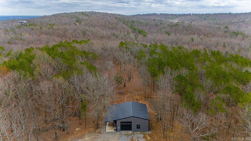 Escape the hustle and bustle with your private wooded sanctuary. Mature trees provide shade and a picturesque setting for potential for expansion or customization based on your unique vision! This one-of-a-kind shop-home is nestled on 5 acres of beautifully wooded land, offering the perfect blend of rustic charm and modern convenience. Open concept living space with high ceilings and natural light. The cozy living area opens to a beautiful kitchen. Enjoy sipping on your favorite beverage on the expansive covered patio where you can entertain or enjoy peaceful moments in nature. This is a rare opportunity to own a property that offers both a distinctive living space and the beauty of nature.