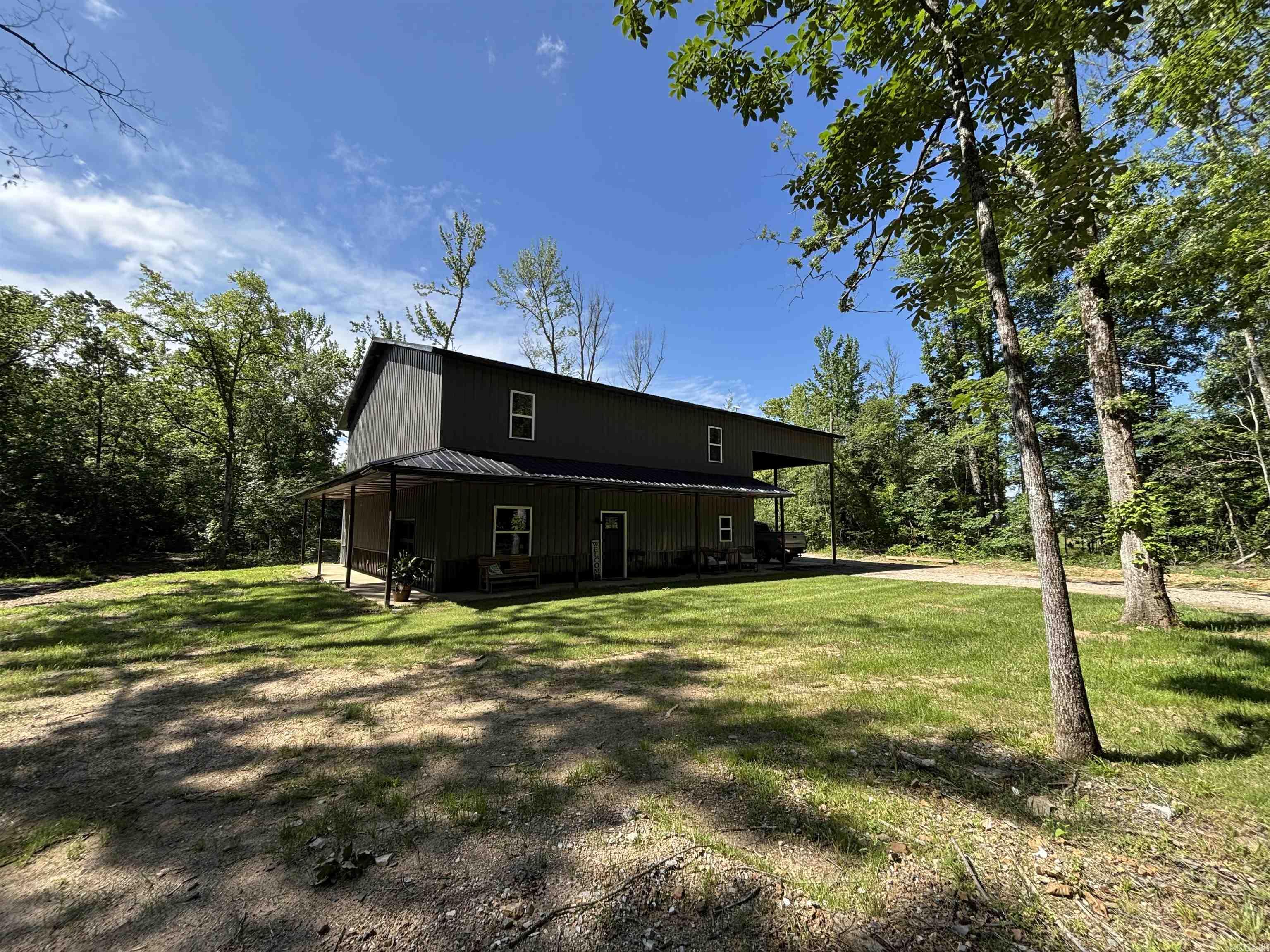 Barndominium style charm meets modern comfort in this spacious 4-bedroom, 3-bath, two-story home in the Jessieville School District! With approx. 2,800 sq ft, this unique property features a game room, office, mudroom, and an open living area ideal for entertaining. The kitchen and dining room showcase stunning tongue-and-groove wood ceilings, adding warmth and character. Upstairs, enjoy a cozy loft and balcony perfect for relaxing with a view. The master bed/bath offers a luxurious whirlpool tub for unwinding. The home sits on 13.09 scenic acres with a beautiful creek that flows into a stocked pond perfect for fishing or simply enjoying nature. A two-car carport and central heating & cooling add convenience and comfort. This one-of-a-kind property combines rustic style with modern amenities don’t miss your chance to own this beautiful property!