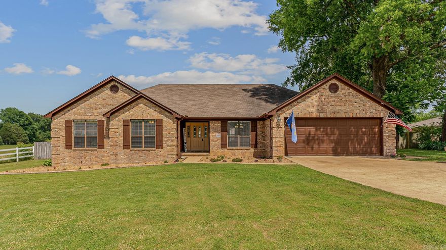 This stunning modern ranch house, nestled on a spacious .94-acre lot with mature shade trees and a privacy-fenced backyard, is truly move-in ready. The single-story home combines contemporary amenities with classic charm. Inside, 5-inch engineered hand-scraped hickory hardwood flooring flows through the living room, dining room, game room, hall, and all three bedrooms. The kitchen features elegant granite countertops, a built-in desk, and ample cabinet space, perfect for culinary enthusiasts. The master suite offers a spacious walk-in closet, a luxurious jetted tub, and a walk-in shower. Two additional bedrooms share a stylishly tiled bathroom. The walk-in laundry room includes a folding station and pantry for added convenience. Multiple living spaces include a formal dining room and a versatile den currently used as a game room. The living room features a cozy gas log fireplace, complemented by indoor LED recessed lighting and outdoor LED lighting. The expansive backyard boasts a 26x21 pergola for relaxation or entertaining, a 20x18 workshop with an overhead door, and beautifully maintained flower beds and mature trees.