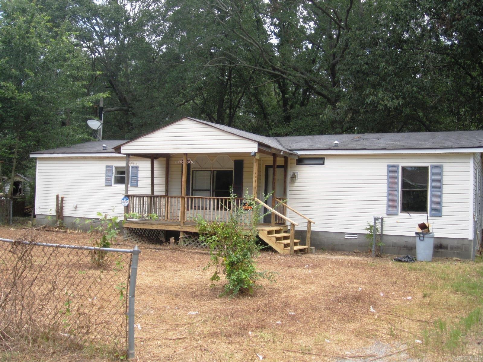 I like this neighborhood. The neighbors are friendly and they watch each others property when someone is away. The property is fenced nearly all around and there are covered party decks on the front and back with new steps for safety. The double wide mobile has been upgraded with fresh paint, carpeting and flooring in the kitchen. There is a split floor plan with the master suite apart from the other bedrooms The living area has a high ceiling and warm wood burning fireplace. The master suite has a garden tub and a shower stall. It is worth your time to come and see this one. *Repairs, paint & flooring are on-going.*