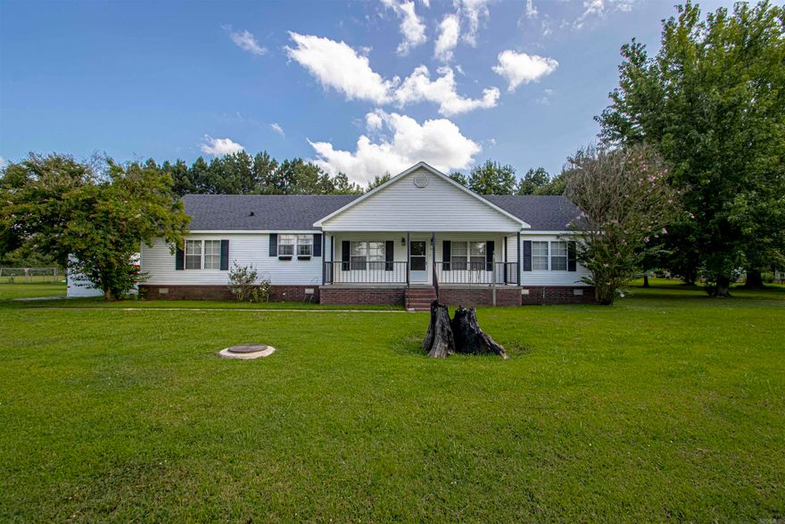 This doublewide is on a permanent foundation, over an acre of land with a storm cellar on site. There is a carport and a little shop with a window unit. Out back you have a screened porch to stay away from the mosquitos - you'll find a walkway to a firepit to cozy up! Come check it out!  AC unit, roof are over 2 years old - Appliances are 5 years old.