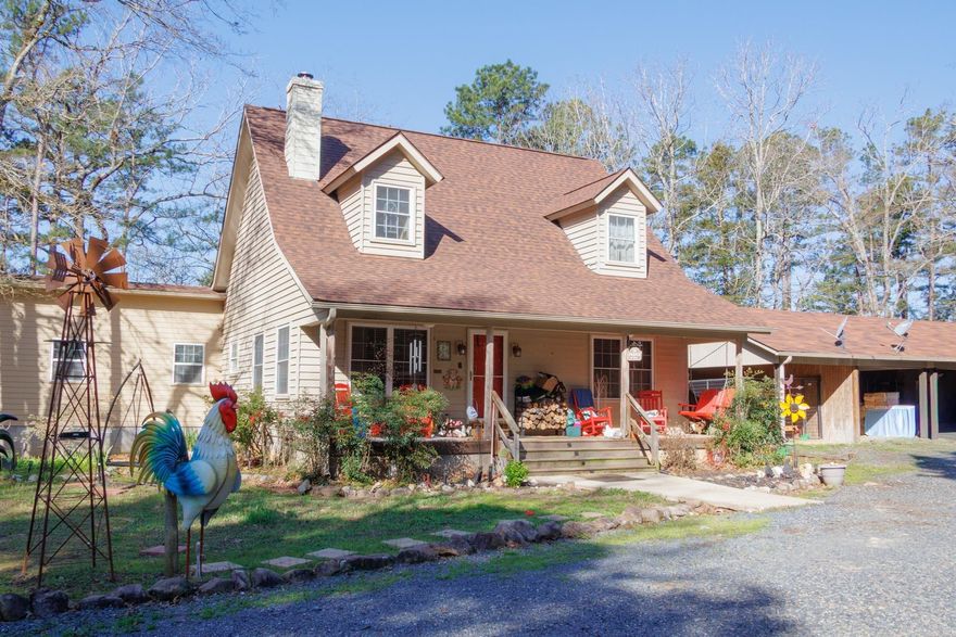 PARK-LIKE SETTING on 21 pristine acres bordering National Forest. This unique 4-bedroom, 3-bathroom home welcomes you with a charming front porch leading into an interior with two spacious living areas, soaring ceilings, and a beautiful cedar stairway. The luxurious Primary suite serves as a true retreat, featuring a spa-like bath and private access to the large deck with a sunken hot tub overlooking the water.  The estate is perfectly equipped for hobbies and guests with a detached garage, a custom carport with a workshop, and a separate building ideal for a private cabin or storage. Enjoy the ultimate outdoor lifestyle at the picnic table on a concrete slab with a dedicated BBQ area, all overlooking the seasonal falls of Hole in the Ground Creek. With 1,200+ feet of creek frontage and private trails, this is a rare outdoor enthusiast’s retreat just minutes from historic Pine Ridge.