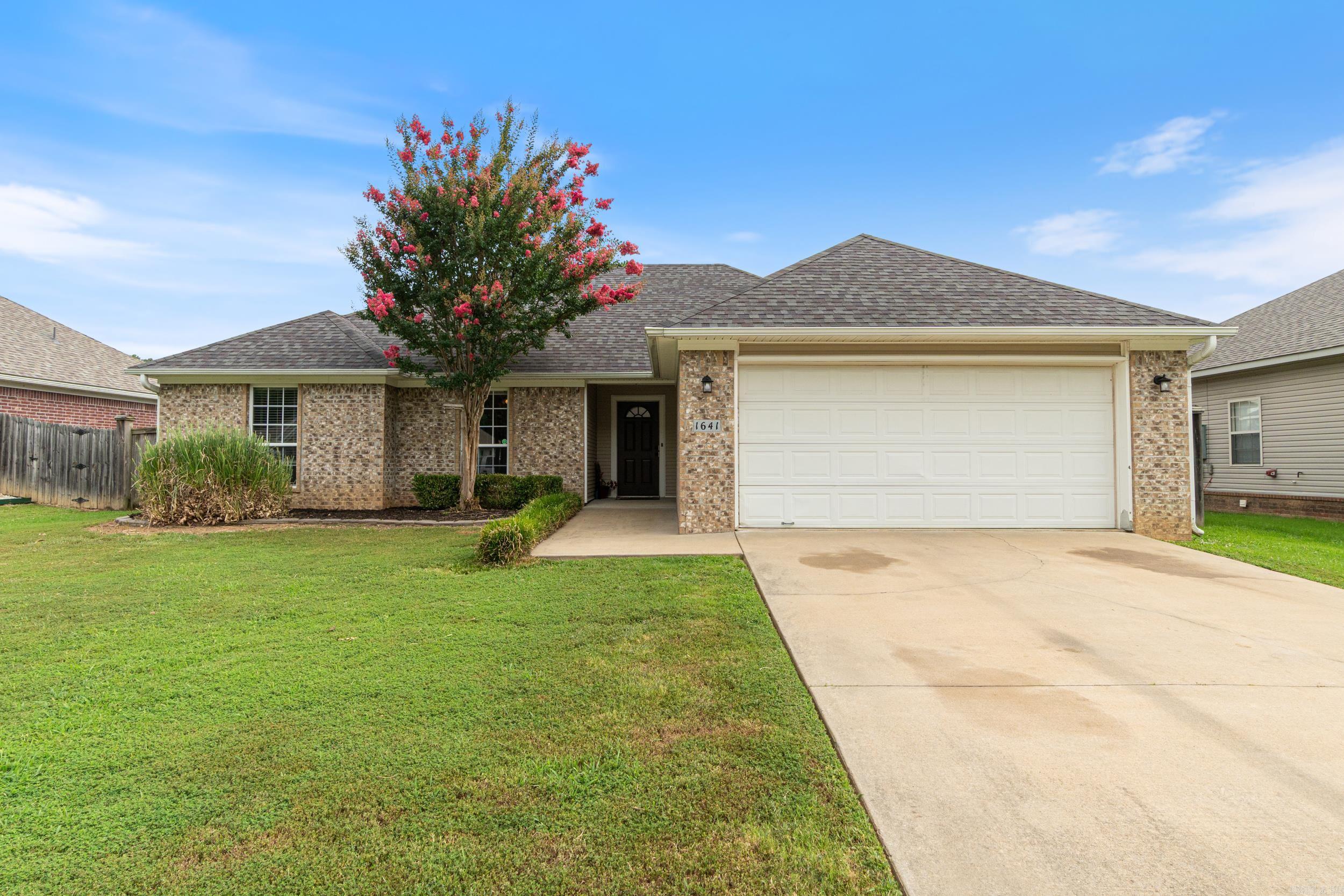 Welcome to Your New Home in The Oaks – Benton, AR! This beautiful 3-bedroom, 2-bath home offers 1,502 sq ft of thoughtfully designed living space in the highly sought-after The Oaks subdivision. You'll love the open floor plan, tray ceiling in the living area, and luxury vinyl flooring that flows seamlessly through the main living area, kitchen, and guest bedrooms, adding both style and durability. The spacious kitchen features a double door pantry, raised bar for extra seating, large window that fills the space with natural sunlight, and plenty of cabinet storage—perfect for home chefs and entertainers alike. Retreat to the carpeted primary bedroom, which boasts ample space, a large walk-in closet, and a private en-suite with tiled flooring. The guest bathroom also features elegant tile for easy maintenance and a clean finish. Step outside to enjoy the wonderful curb appeal, a fully fenced backyard, and a cozy pergola covered in wisteria, offering the perfect shady spot to relax or entertain. Located just minutes from Hwy 5, I-30, shopping, and dining, this home offers both comfort and convenience in one of Benton’s most charming neighborhoods—The Oaks. Agents see remarks!