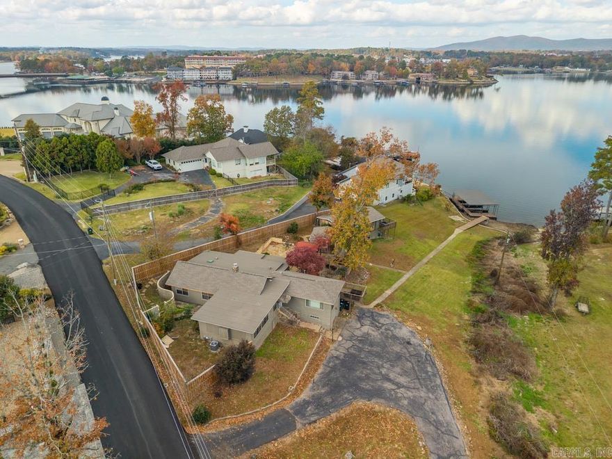 Incredible Multi-Home Lakefront Property on Lake Hamilton! Located on highly desirable Long Island Drive, this unique property offers exceptional versatility, investment potential, and breathtaking main-channel views. With nearly one acre of land and over 100 feet of lake frontage, this rare find includes two full homes, a guest cabin, a three-stall covered boat dock, and a beautifully designed courtyard ideal for entertaining.  The main home (road-side) features 3 bedrooms and 3 full baths, while the guest home (lake-side) includes 2 bedrooms and 1 full bath. Between them sits a fully equipped guest cabin with kitchenette and full bath—perfect for overflow guests, a private office, or an additional rental space.  Recent updates include new roofs on all structures, newly renovated bathrooms, modern interior touches, and preserved mid-century character. The property has a proven history as a successful short-term rental and is located outside city limits—no STR permit required. All furnishings convey, offering a turn-key opportunity for investors or those seeking a multi-home lake retreat.