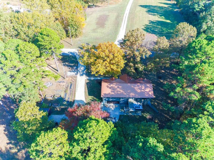 Check out this peaceful homestead located right off the pavement on the ridge.  Half of the property is fenced and set up for livestock with a pond, chicken coop, and garden area. The remaining acreage is wooded, offering privacy and abundant wildlife. This spacious home features 2 living areas, a walk-out basement, and a large eat-in kitchen. 4 bedrooms, 3 baths, new HVAC, and a metal roof. The detached shop provides ideal space for hobbies, work, or homesteading needs. You will find a quiet setting with a practical layout—perfect for country living but close to town.