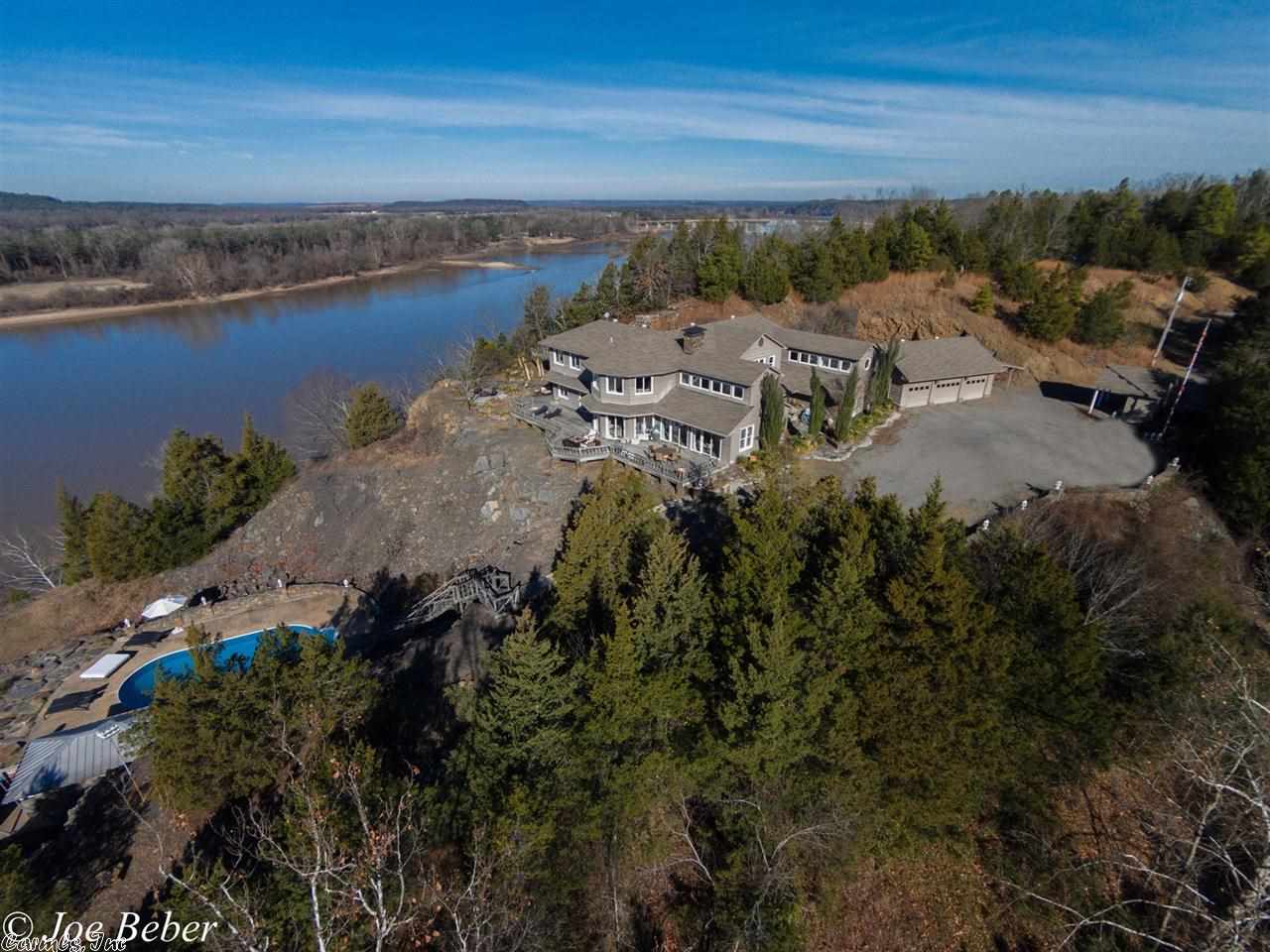 Spectacular, one of a kind estate set upon a 300ft bluff overlooking the Arkansas River!  Private drive/gate lead to sweeping River Valley vistas.  Set on 17+ acres, LollyRock offers it all.  Three master suites all with incredible views.  Native stone floor heated and cooled by geothermal energy.  25 ft stone fireplace, towering ceilings encase the 2 living areas.  Kitchen with all the emenities inc SubZero refrig.  Large wrap around deck overlooks custom pool w pool house.  Gameroom and billiard rooms.