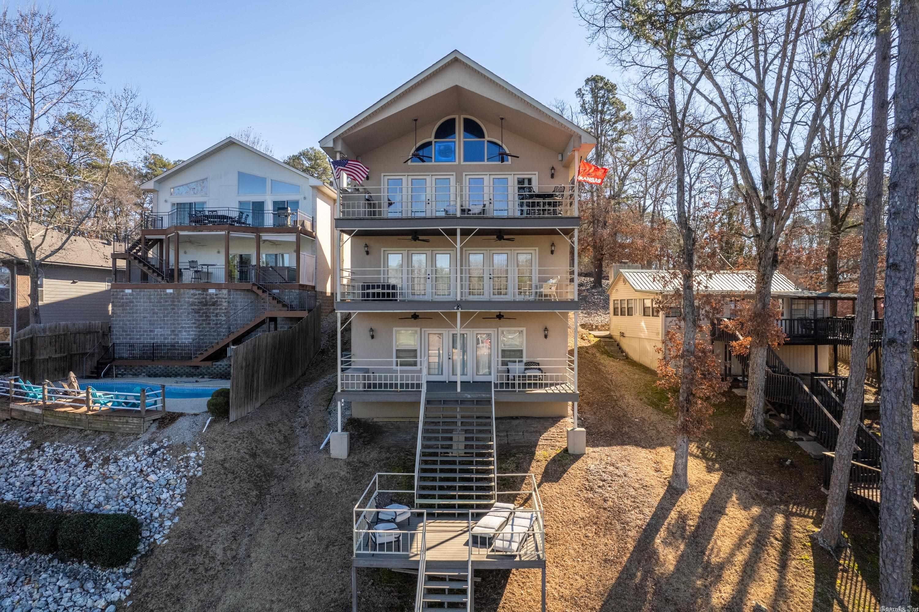 Must see this beautiful 4 Bedroom 4.5 Bath home on Lake Hamilton! The interior includes an open floor plan w/vaulted ceilings, a chef's kitchen, and large primary bedroom/bathroom on the main level. The second level includes three bedrooms, a secondary living space, multiple bathrooms, and a kitchenette. The exterior includes multiple decks to enjoy the beautiful lake views, an outdoor cooking area with a built in gas grill, a two car garage, and additional parking. Call for your private showing today!