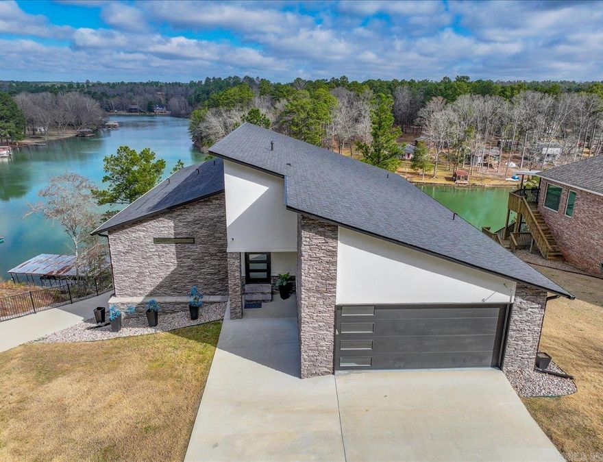LUXURY LAKEFRONT LIVING ON LAKE HAMILTON!   Welcome to this stunning, modern lakefront home in a STR friendly gated community. Featuring 6 bedrooms, 3 full baths, 2 half baths, and 3 laundry rooms, this home offers year-round water access and breathtaking views.  Both levels have full kitchens with quartz countertops, Café appliances, and an on-demand generator for uninterrupted comfort. The outdoor space is equally impressive, with a gunite infinity pool overlooking the lake so you can feel like you're living in your own private paradise. A single-bay boat dock with a trolley system provides easy lake access for boating, fishing, and all your favorite water activities.   Designed for relaxation and entertainment, the home’s expansive windows flood the space with natural light and lake views, while multiple living areas provide plenty of room for guests. You'll have luxury, convenience, and serene lakefront living in this home.  Here's your opportunity to own a slice of paradise on Lake Hamilton! SCHEDULE YOUR SHOWING TODAY!  Agents - Call Showing service to schedule all showings.