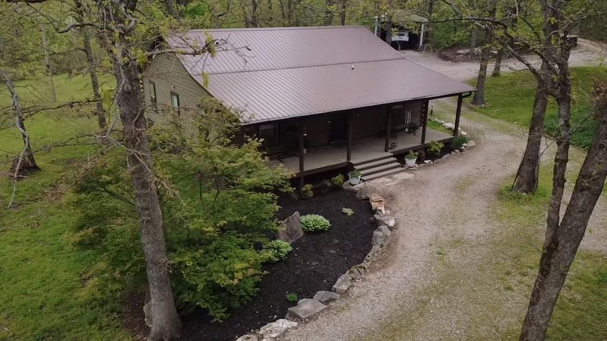 Buyer and agent incentives! $4000 credit to buyer at closing and $1000 to selling agent if under contract by June 1 2026! LOG Home in Fulton County on 5.41 Acres. 3 bed, 1 bath log home offering 1,769 sq ft of rustic Ozarks charm with modern upgrades. Dishwasher and refrigerator(2026) Open floor plan, featuring hardwood floors, vaulted tongue-and-groove wood ceilings, and metal ceilings in the sunroom and bedrooms. REMODELED full bathroom (2026) with a genuine PORCELAIN claw foot tub. Covered front and back PORCHES to enjoy the peacefulness.  A new metal roof (2024), ELECTRIC/SOLAR heat pump, propane fireplace, and SPRAY FOAM insulation under the floor provide year-round comfort and energy efficiency. Home is inside city limits; acreage is outside city limits for added flexibility. CITY WATER and septic system included. Situated on 5.41 acres with a SEASONAL CREEK, this property is ideal for deer hunting and outdoor living. Enjoy a private shooting range, circle driveway, extra landscaping with beautiful huge boulders, dogwood, pecan, weeping willow trees and crepe myrtle, Japanese maple. 4 outbuildings, and a NEWER SHOP (2024) perfect for equipment, storage, or workshop space.