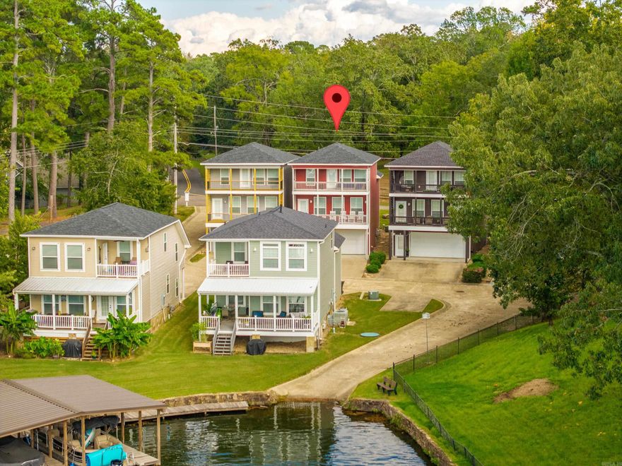 This modern, coastal-style villa sits just off the shores of a peaceful cove on Lake Hamilton. As soon as you arrive, the vibrant exterior colors and clean architectural lines give this private 6-home community its charm. Located in the highly sought after Bayshore area of Lakeside School District, this neighborhood was designed for those who love to live and play by the lake - offering its own boat ramp and community boardwalk. Inside, you’ll find an open, airy floor plan with 3 bedrooms and 2 baths, recently updated with hardwood flooring in the main living areas. Abundant natural light floods through the abundant windows, and two spacious balconies extend your living space outdoors for entertaining or simply soaking up the views. An oversized attached garage provides plenty of room for vehicles, kayaks, and lake toys, making it easy to enjoy everything this lakeside lifestyle has to offer. Best of all, this property allows nightly rentals, making it an ideal investment or personal retreat. (New roof installed and new decking installed on both balconies in 2023.)