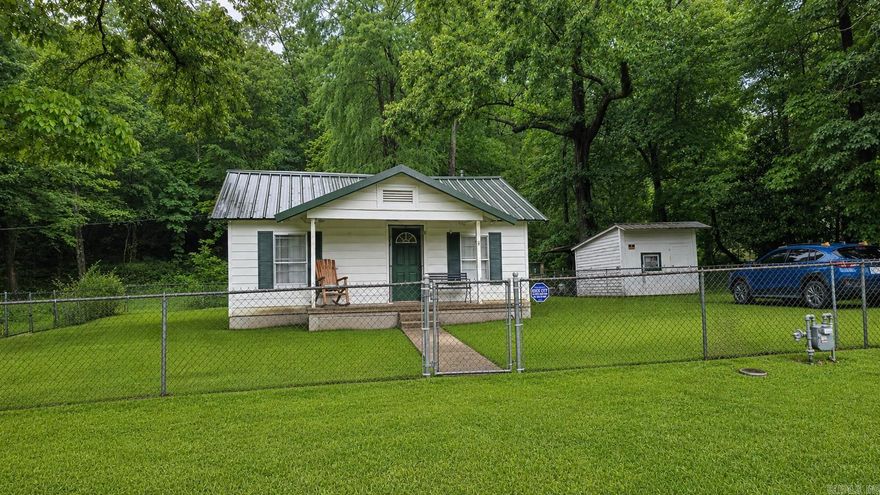 CUTE 1930's farmhouse!! This cute farmhouse sits on just over an acre.  The home boasts hardwood floors, new interior paint, new gas range, new faucets and new commode.  New gas water heater.  Metal roof only 6 years old. Large laundry/ utility room.   Fully fenced yard.  Property goes beyond fence line. Outbuilding.  level lot.  Great location!! Located in Hot Springs just outside Fountain Lake.   See agent remarks.