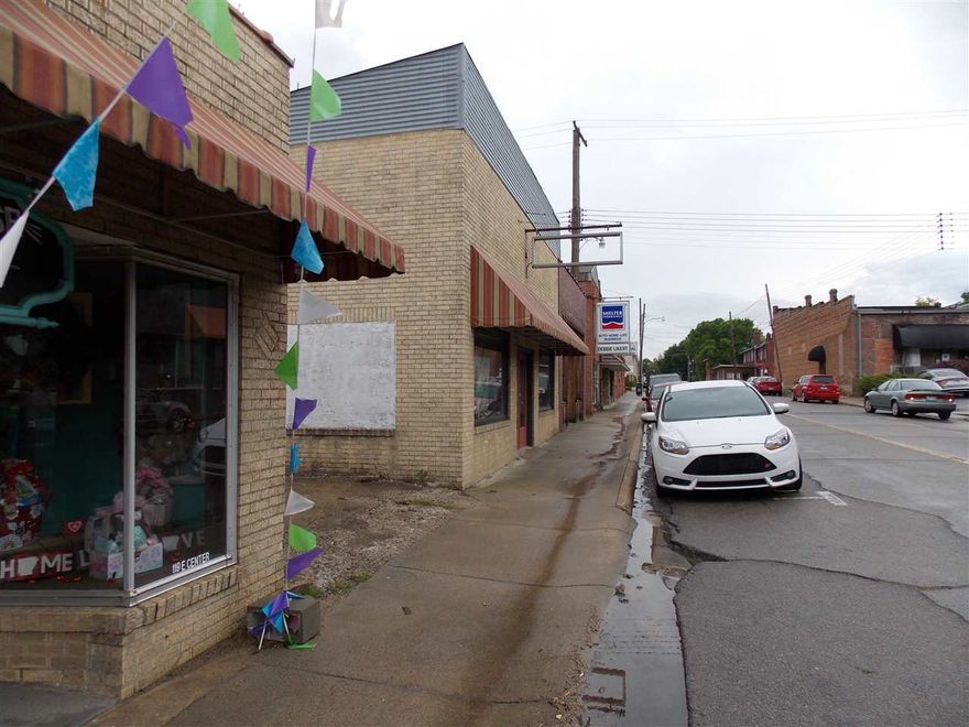 Great retail or professional space.  First smaller building is stand alone brick, second building is zero lot line as downtown space and has the 3 large metal bay storage units to the south.  Both buildings need repairs, sold as is.  See remarks