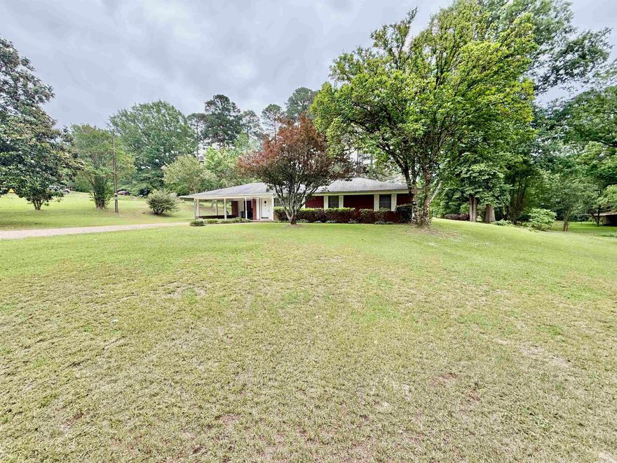 Three bedroom, two bath property located just outside the city limits on a spacious lot where you can enjoy beautiful golf course views. This property features a functional layout with a mudroom and laundry room conveniently located off the carport and kitchen. The refrigerator will remain with the property. Inside you will find both a living room and a den, along with a fireplace located in the dining room that adds warmth and character. The property also backs up to the country club for a peaceful setting. Enoy the views on your covered back porch! Like golf? Even better, join the Camden Country Club and drive straight on the course for a round or two!!