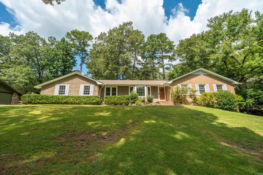 Welcome to this beautifully maintained single-level home that blends timeless character with modern updates. Nestled on a spacious lot surrounded by mature trees, this property offers privacy, comfort, and plenty of room to enjoy both indoors and outdoors.  Step inside to find a warm and inviting living room with wood-beamed ceilings, and a cozy brick fireplace—perfect for gatherings or relaxing nights in. A second living area with large picture windows brings in abundant natural light, creating a bright, airy space ideal for entertaining or family living.  The kitchen features ample cabinet space, a convenient layout, and views of the backyard. Retreat to the primary suite and enjoy the renovated bathroom boasting dual sinks, a walk-in shower with custom tile, and modern finishes, large laundry room.  Outdoors, the backyard includes a patio surrounded by mature landscaping, offering a retreat for entertaining, dining al fresco, or simply enjoying the peaceful setting.