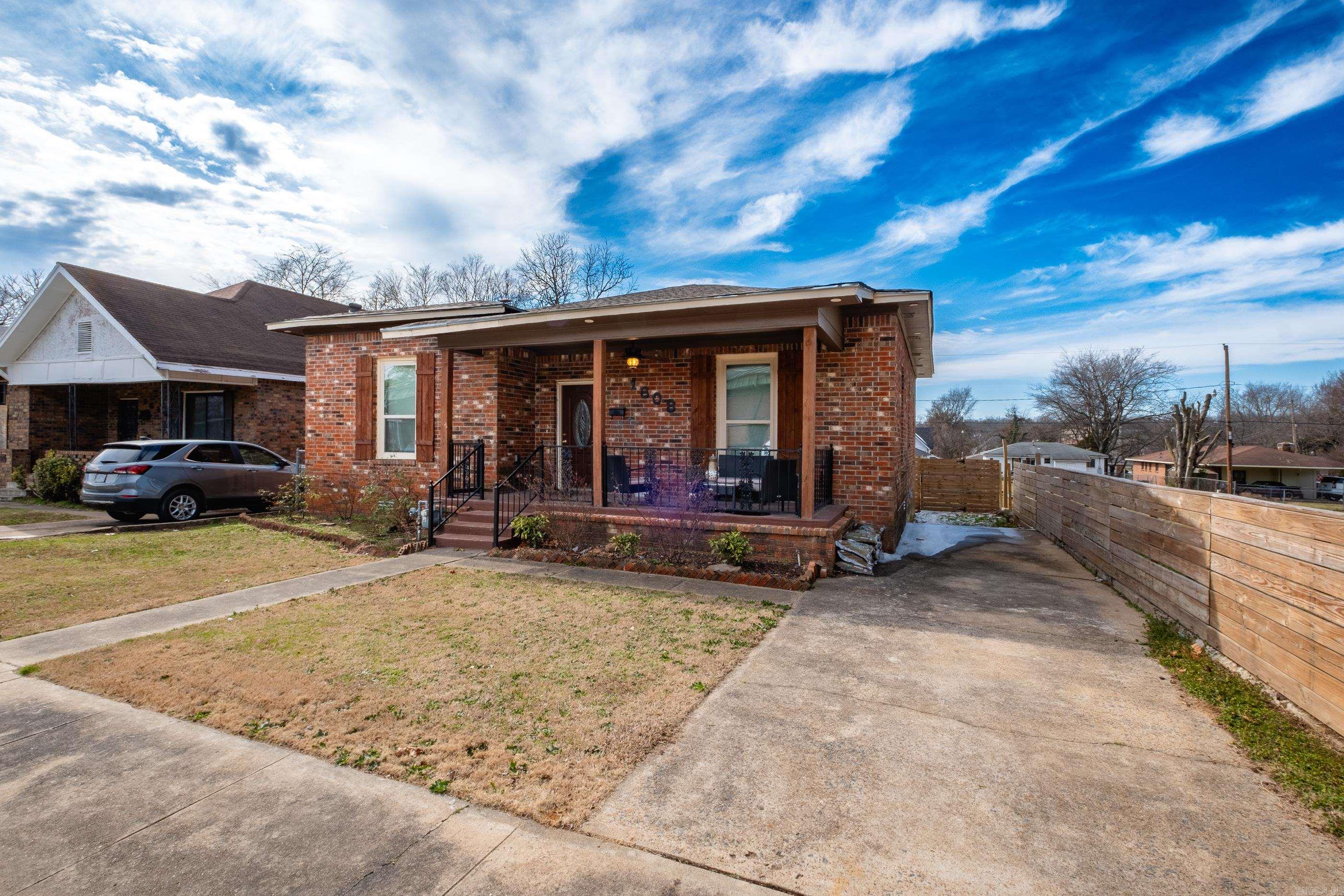 Possible grant money and down payment assistance available! Welcome to this stunning 2-bed, 2.5-bath brick home in Little Rock, offering 1,581 sq ft of modern living! Located just minutes from all the shopping, dining and fun Downtown has to offer. Just a hop across the river from the Argenta Arts District. Close to UAMS and Children's Hospital. - New Roof, New AC and Furnace, New Fencing and New Hot Water Tank! - Step into an open-concept layout with gleaming hardwood floors, elegant tray ceilings, and a chic chandelier in the living area. The gourmet kitchen features stainless steel appliances, granite countertops, a large island with a breakfast bar, and white cabinetry. The primary suite impresses with tray ceilings, ample light, and a serene ensuite bath with a sliding barn door and walk-in shower! The second bedroom is perfect for guests or a home office. Outside, enjoy a well-kept lawn, a charming front porch, and a private and very spacious fenced backyard—ideal for relaxing or entertaining.