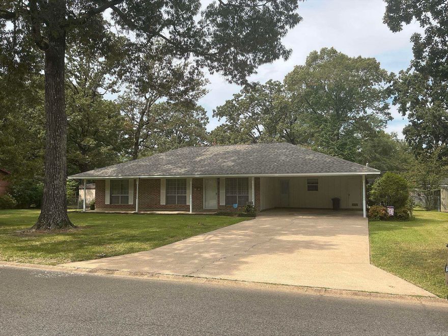 This beautiful move-in-ready home features sitting on a large lot has a wonderful floor plan with a large formal living room, formal dining room with built-ins, large den (640 sq ft) with fireplace and built-ins, backdoor leading to the covered patio and large backyard, kitchen with double ovens, dishwasher, refrigerator,  and small breakfast area with double doors leading to the formal dining room, laundry room with storage over w/d, tile floors in kitchen and laundry room, luxury vinyl is in the den, formal dining room and hall,  three bedrooms with carpet,  large closets, two full baths, hall bath with shower over bathtub, and the master bath also with shower over bathtub.  Home also features beautiful curb appeal, a double carport with concrete driveway, outside storage building, privacy fence in the backyard and cyclone fence in front,  covered patio and side porch also.  The central unit is gas heat, 2005, hot water heater gas and a new Architectural roof, August 2025.  Property is located within walking distance to Anderson School and park with the exercise equipment.  This home is one you must see to know all the amenities.