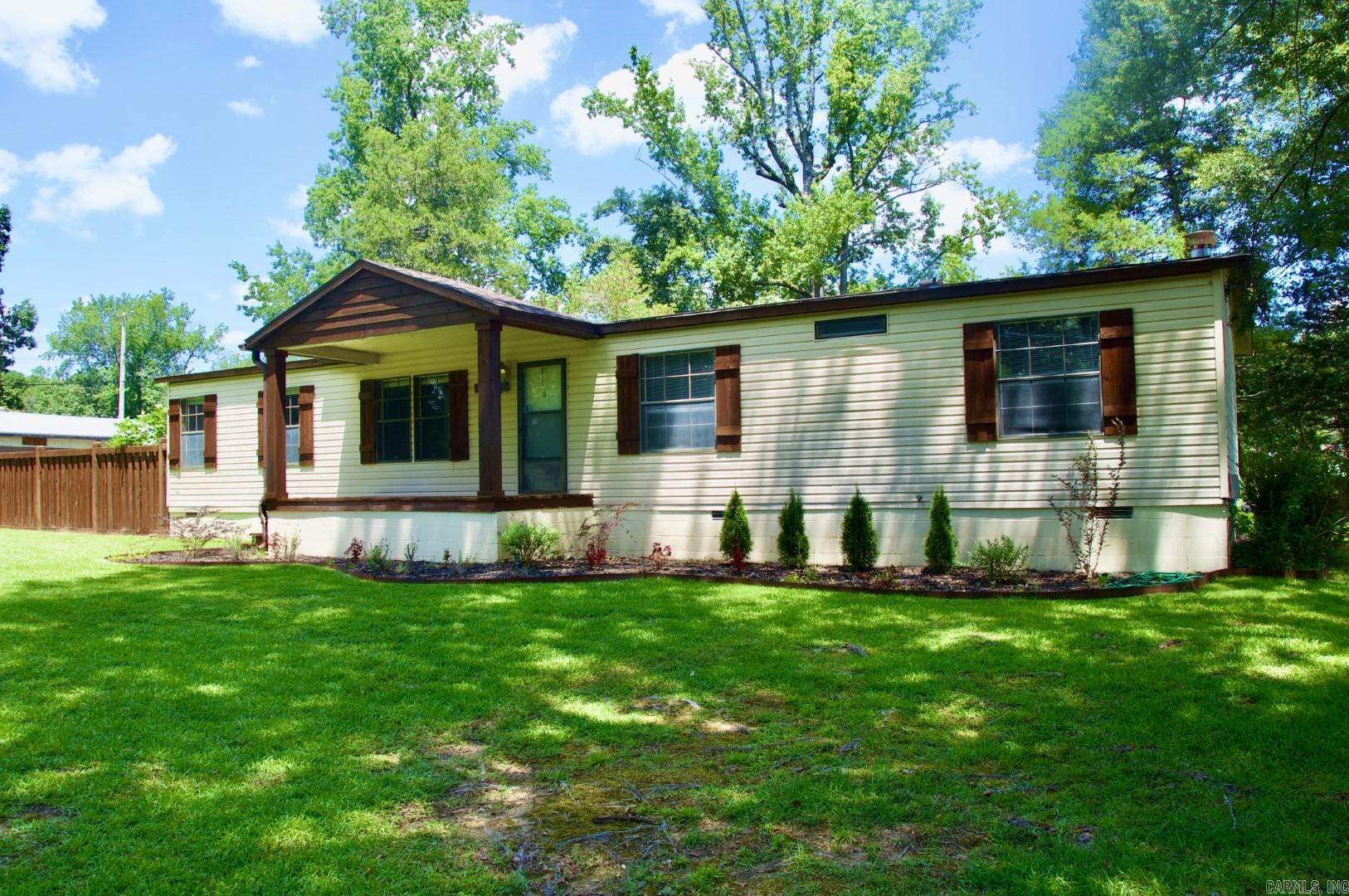 Lakefront property with 150ft of shoreline on Lake Hamilton with deep water near the main channel! Situated on .57 acres outside city limits and not subject to HOA restrictions. Enjoy lake life with a boardwalk over the water, a patio for lounging, and outbuildings for storage or hobbies. The back porch, with its vast windows, is perfect for relaxing and entertaining. The house features several updates, including new fixtures and custom cabinets. This is your opportunity for prime waterfrontage on a budget!
