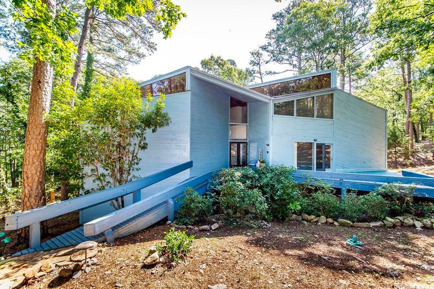 Back on Market!!  Great updates, carpet, paint, amazing spacious 3735 sq. ft architecuturally designed contemporary brings the outside in, nestled in woods. Security gate opens to winding paved drive leading to total private setting, surrounded by 3 decks & 3 story glass walls. Wood ceilings, floors, 2 massive native rock fireplaces complete this unique home located on 2.78 acres. Cherry cabinets w/granite. Marble steps lead to circle drive. Endless storage throughout house. Built on massive concrete pilings. New shop 20' x 30', auto garage door opener. New HVAC 2022. New Survey.