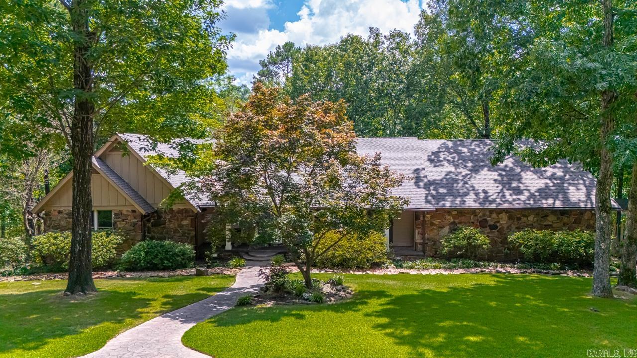 Tucked away on a private drive, this home offers the space, serenity, and smart layout that so many are looking for. Floor-to-ceiling windows bring in natural light and frame peaceful wooded views, creating a cozy atmosphere whether you're curled up by the fireplace or sipping coffee on the expansive back deck listening to the birds. The primary suite feels like a retreat, with large windows that make waking up feel like a weekend escape. Guest and kids' rooms are tucked downstairs for extra quiet and privacy throughout the home, making everyday living feel calm and balanced. Fresh paint, new flooring, updated bathrooms, and a new roof mean you can move in without a to-do list. The layout includes a dedicated office, bonus room, and generous living space for work, play, and everything in between. The deck runs the full length of the house and overlooks a creek and pond, offering a quiet place to unwind. Evenings here feel like vacationāpeaceful, green, and full of charm. Fireflies, birdsong, and breezes through the trees add to the magic. With a neighborhood pool, nearby parks, shopping, and top-rated schools, you get the best of both nature and convenience.