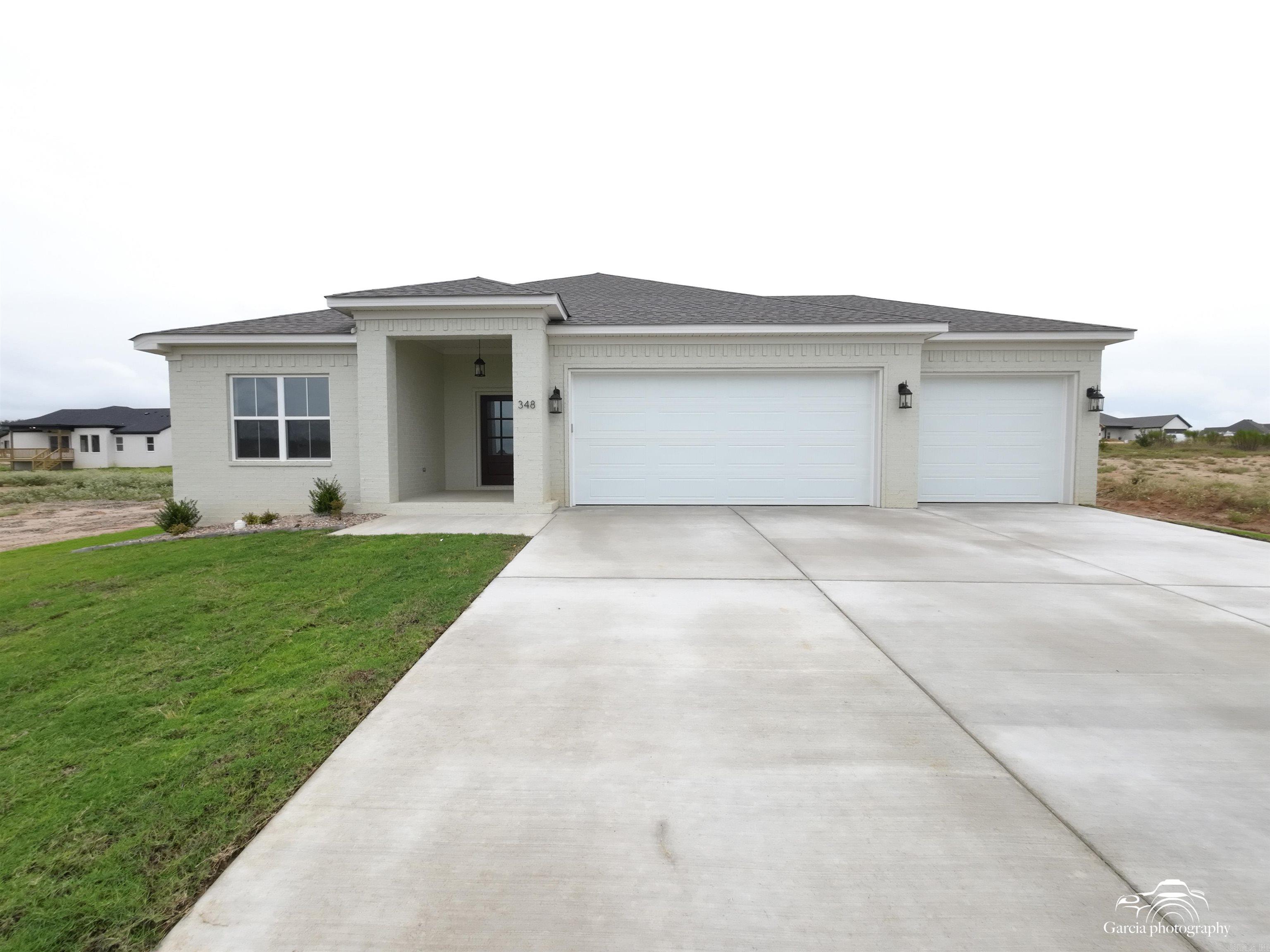 This open-concept home features large windows in the kitchen and living area, along with three bedrooms and two bathrooms arranged in a split floor plan. It boasts luxurious laminate flooring and carpet in the bedrooms, a walk-in shower with tile in both bathrooms, and a spacious walk-in closet in the master suite. Additional highlights include a three-car garage, energy-efficient Low E windows, spray foam insulation, and elegant quartz countertops complemented by a stylish tile backsplash. This property is designed for multi-generational living.