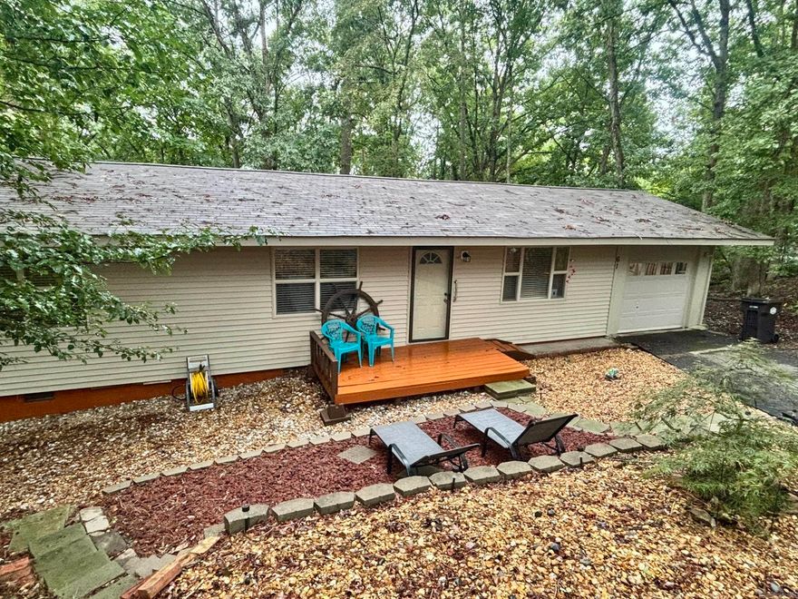 Located in a cute neighborhood with a welcoming feel, this charming three bedroom, one- and one-half bath home is ready for its next chapter.  Step out on to the back deck and enjoy the peaceful wooded backyard ideal for relaxing, hosting barbecues or simply soaking up the quiet setting.   A convenient one car garage adds extra storage and parking and includes an area for a workshop and washer and dryer connections.  New roof 2025.  Perfect for first time home buyers or investors. It's a great opportunity to invest in comfort, charm and value. This home is move in ready. Furnishings negotiable. All new property owners in Hot Springs Village have a $2,000.00 new member buy in fee due at closing.