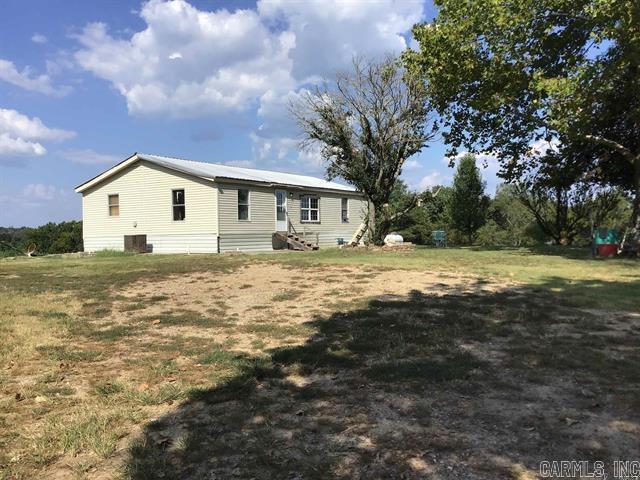 Great Mountain views from this hilltop home & outbuildings over looking the 40 acres of beautiful hay meadows in front & pastures to the back with year round Buffalo Creek bordering the back of property & a wonderful large stocked, spring fed pond. Come & enjoy this wonderful country life swimming, fishing & canoeing without leaving home but a short distance away are lots of National Forest, ATV trails, Gilham Lake, DeQueen Lake, Broken Bow Lake, Talimena Drive, & great hunting, fishing & lots of water sports. At the end of the day retire to this homey 1200 SF, 3 Br, 2 bath home & man cave. They are leaving a really old Oxen Yoke that has been made into a light fixture for the kitchen to go along with the historical tin ceiling there. The living room, dining, & kitchen are all open to each other, with a split floor plan for the bedrooms. The man cave is in a separate building & could become a guest house quarters. The yard is full of flowers & old & beautiful flowering & fruit trees that make spring & summer so pretty here. A large barn will hold the hay that is produced on this property. No Restrictions are on this Property!