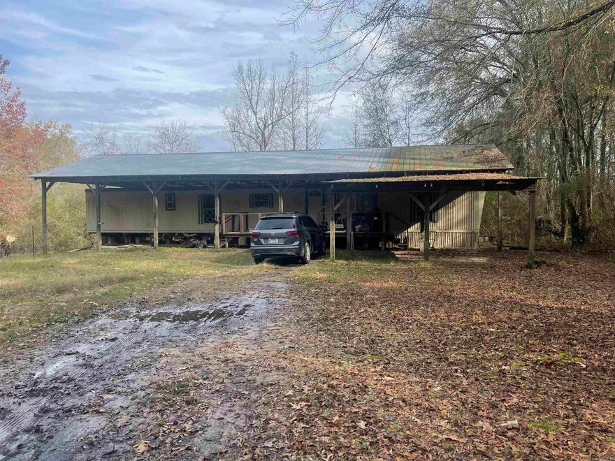 This mobile home was built 1974 and sits on 4 secluded acres.  Railroad runs along the N/W side of the property.   It is covered by a 30 x 70 pole barn with a metal roof, covered porch, a 16 x20 carport.  This home is in need of repairs, being sold as is. A great location as a hunting get away or a trip to Dierks Lake.