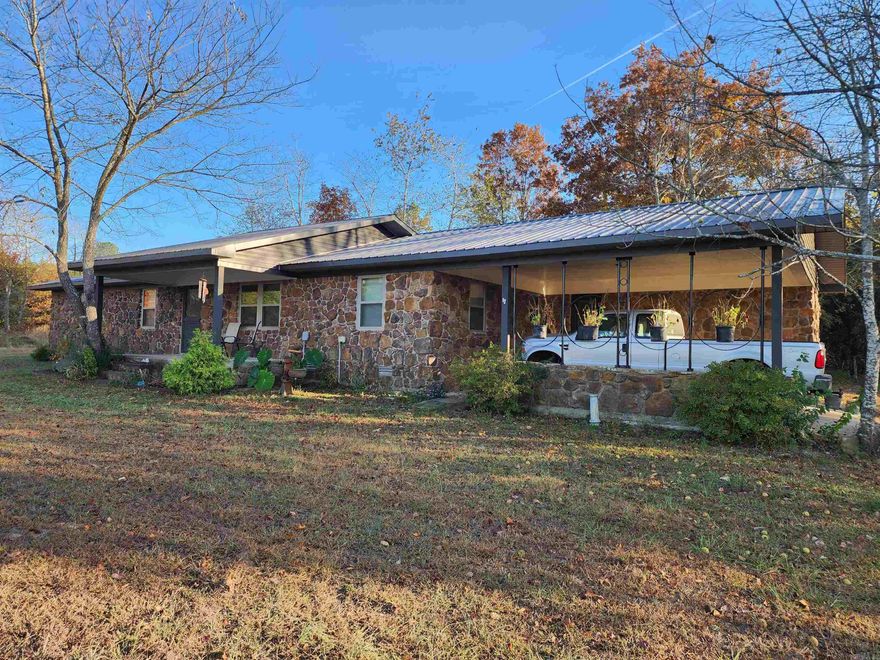 Welcome to your dream home in Quitman, Arkansas! This beautifully remodeled 3-bedroom, 2-bathroom residence features a stunning rock exterior and is situated on a spacious 1-acre lot.  The inviting front porch welcomes you, while the expansive yard, surrounded by mature trees, offers ample space for outdoor activities and gatherings. Inside, the open floor plan showcases warm laminate wood floors throughout.  The spacious living room is filled with natural light and offers a versatile layout for entertaining. The remodeled kitchen boasts beautiful butcher block countertops, modern appliances, and custom cabinetry, with a large island perfect for casual seating. The bright dining area provides lovely views of the backyard, enhancing family meals.  The master suite features an ensuite bathroom, while two additional bedrooms provide versatility for guests or home offices. Both bathrooms have been tastefully updated.  With a serene 1-acre backyard, perfect for gardening and outdoor fun, this home is ideal for those who appreciate country living. Conveniently located near local amenities and outdoor recreation, this property is ready for you to call it home!