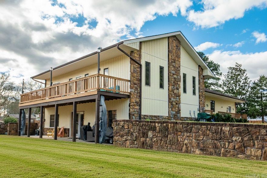 Modern-country lake living at its best! Beautifully Remodeled Lakefront home in Lake Hamilton situated on a rare flat lot with easy water access.  Enjoy your own Private Boat Ramp, Covered Boat Dock, Seawall, and RV parking with hookup for effortless lake days.  Inside features an inviting open-concept kitchen and living area designed for entertaining. The home offers Two Primary Suites and a large office with built-in stove and wood-burning fireplace.   Expansive patios and decks extend the living space outdoors, providing the perfect backdrop for entertaining, relaxing, and enjoying the peaceful waterfront setting.  Turnkey waterfront property ready to enjoy cool and refreshing lake days! See Agent Remarks