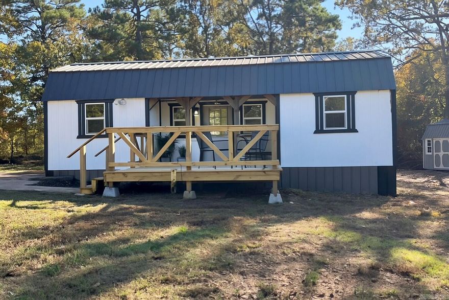 Charming modern tiny house retreat! Enjoy the serene, wooded setting, stylish black-and-white exterior, and inviting front porch, perfect for enjoying morning coffee or evening sunsets. Inside, the layout maximizes efficiency with a bright, open concept living space, cozy kitchen area, along with a bedroom and bath. A versatile loft adds flexible space for sleeping, storage, or a reading nook, making smart use of every inch of this thoughtfully built retreat. Cute storage building in the back. Surrounded by nature, yet conveniently located near local amenities, this property makes an ideal minimalist homestead or air bnb investment! Book your showing before it's gone!