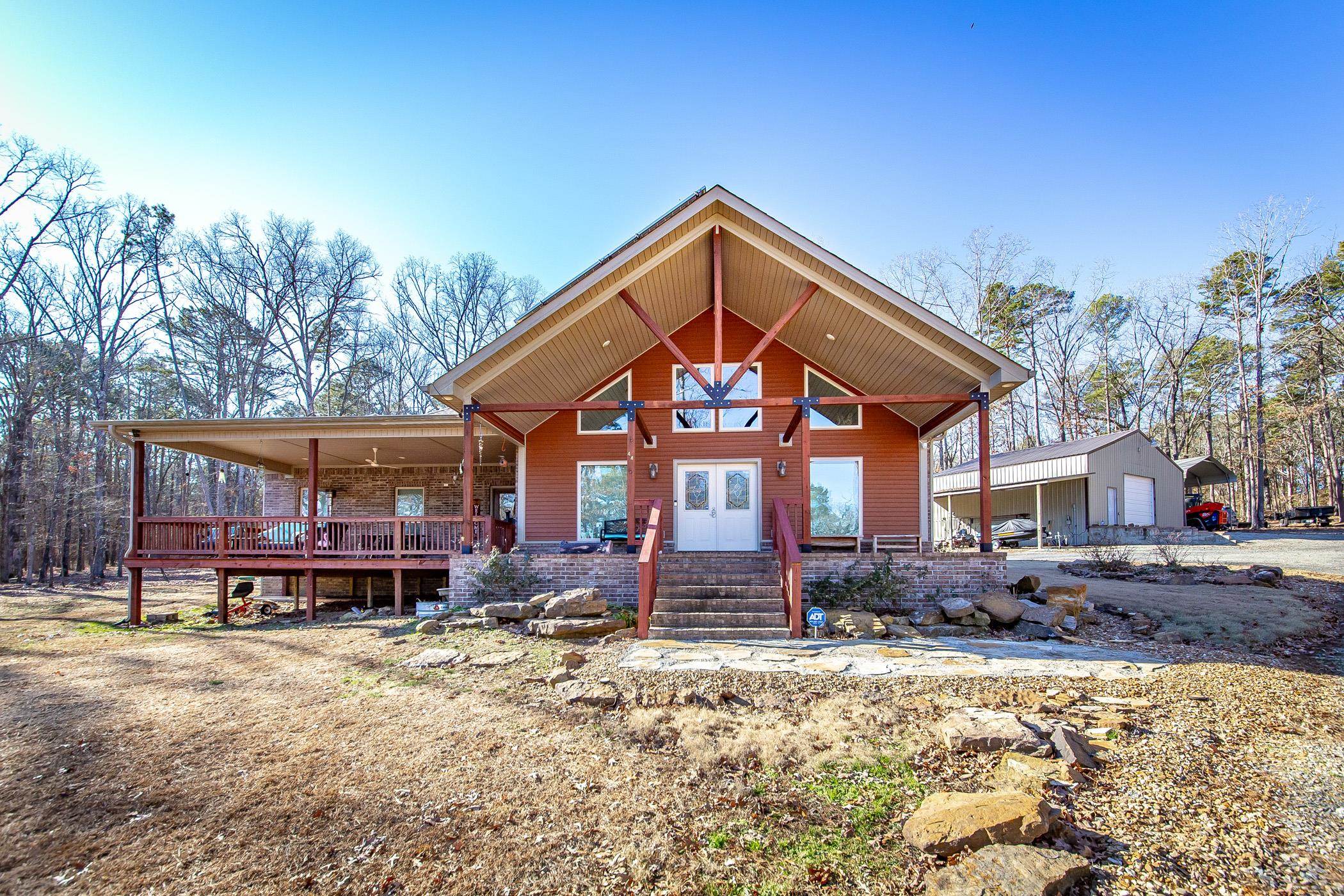 Discover your dream retreat on the picturesque shores of Greers Ferry Lake. This stunning lakefront property spans 2.8 acres +/- offering the ideal blend of privacy & space, with direct access to a convenient boat ramp. Nestled next to the renowned Tannenbaum Golf Course, spend your days perfecting your swing under the sun, & your evenings basking in the vibrant hues of lakefront sunsets, or catching a wave on your boat. The expansive covered patio sets the scene for unforgettable gatherings while the serene mornings provide the perfect backdrop for a quiet coffee ritual as you watch the lake’s still waters. Inside, the open & vaulted living/dining area is bathed in natural light, courtesy of a striking wall of windows that offer uninterrupted views of the lake. This property is as efficient as it is beautiful, with solar panels providing significant energy savings. Custom trim was harvested from local trees on the land. Storage is abundant, with two carports & a spacious 30x36 insulated shop building, ideal for those cherished lake toys. The shop is roughed in for plumbing offering the opportunity for expansion to add a guest suite. Your lakeside sanctuary awaits.